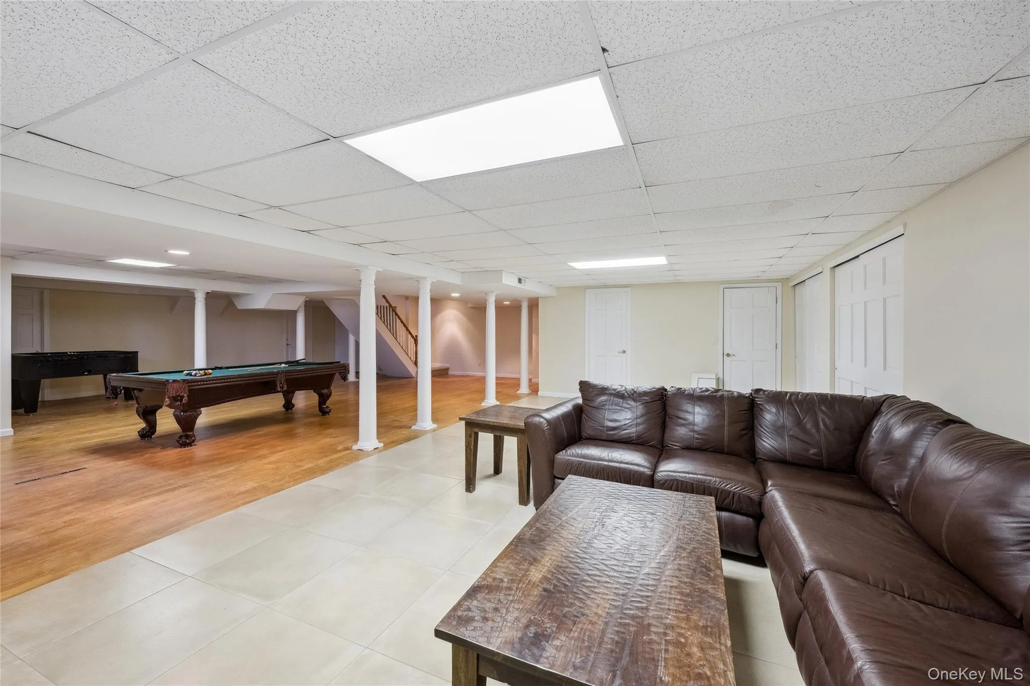 Living area with light wood-style floors, a paneled ceiling, and pool table Living area with light wood-style floors, a paneled ceiling, and pool table