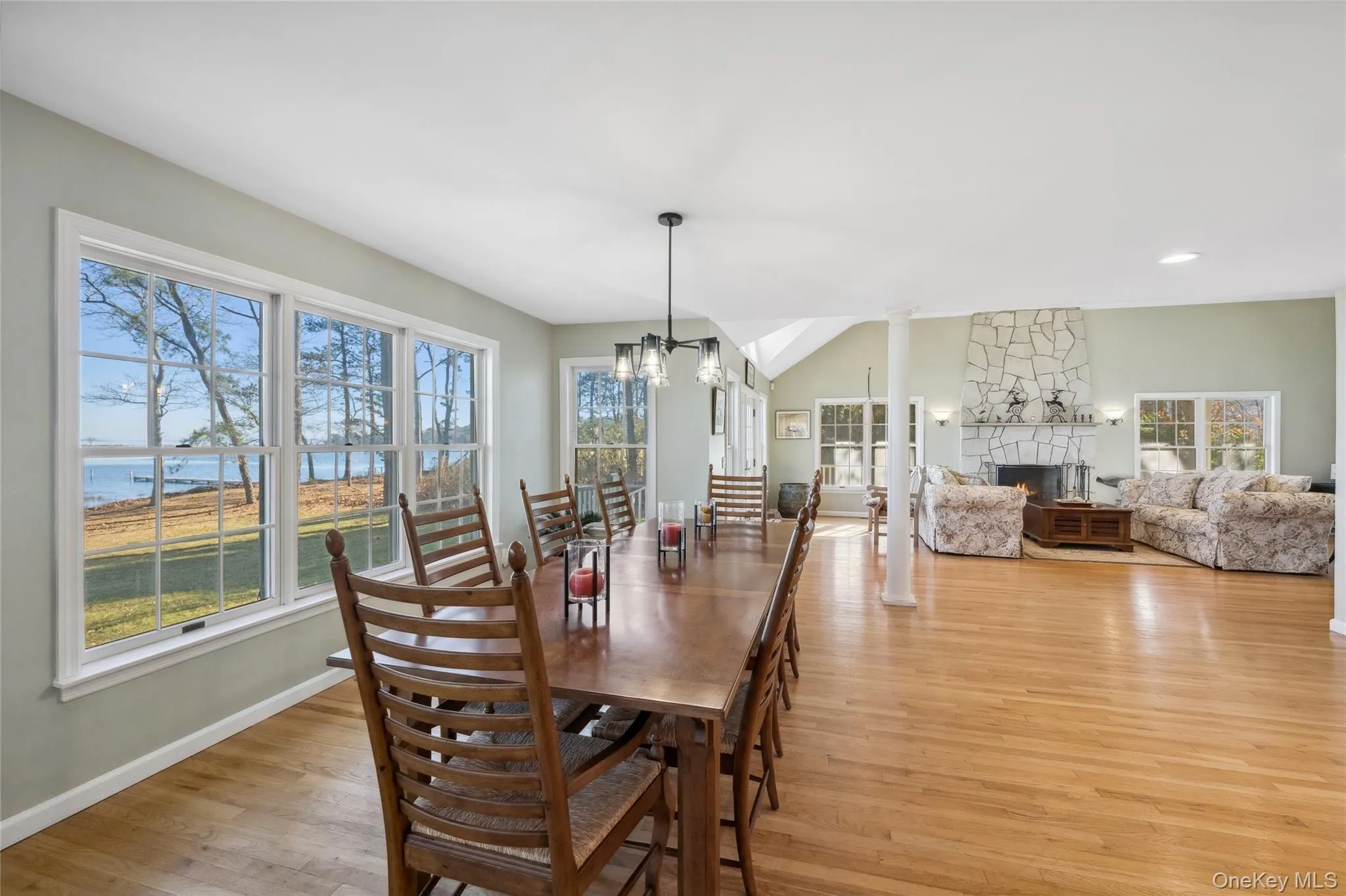 Dining area with a chandelier, light wood-style floors, a fireplace, and baseboards Dining area with a chandelier, light wood-style floors, a fireplace, and baseboards