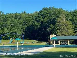 View of property's community featuring a playground and a yard View of property's community featuring a playground and a yard