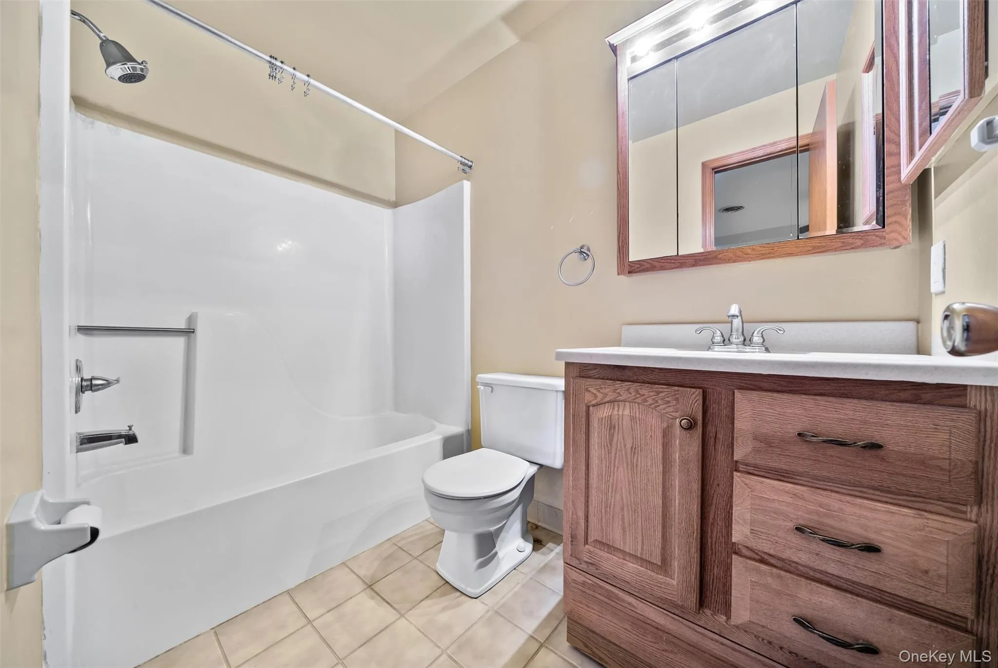 Full bathroom featuring vanity, tile patterned floors, toilet, and shower / washtub combination Full bathroom featuring vanity, tile patterned floors, toilet, and shower / washtub combination