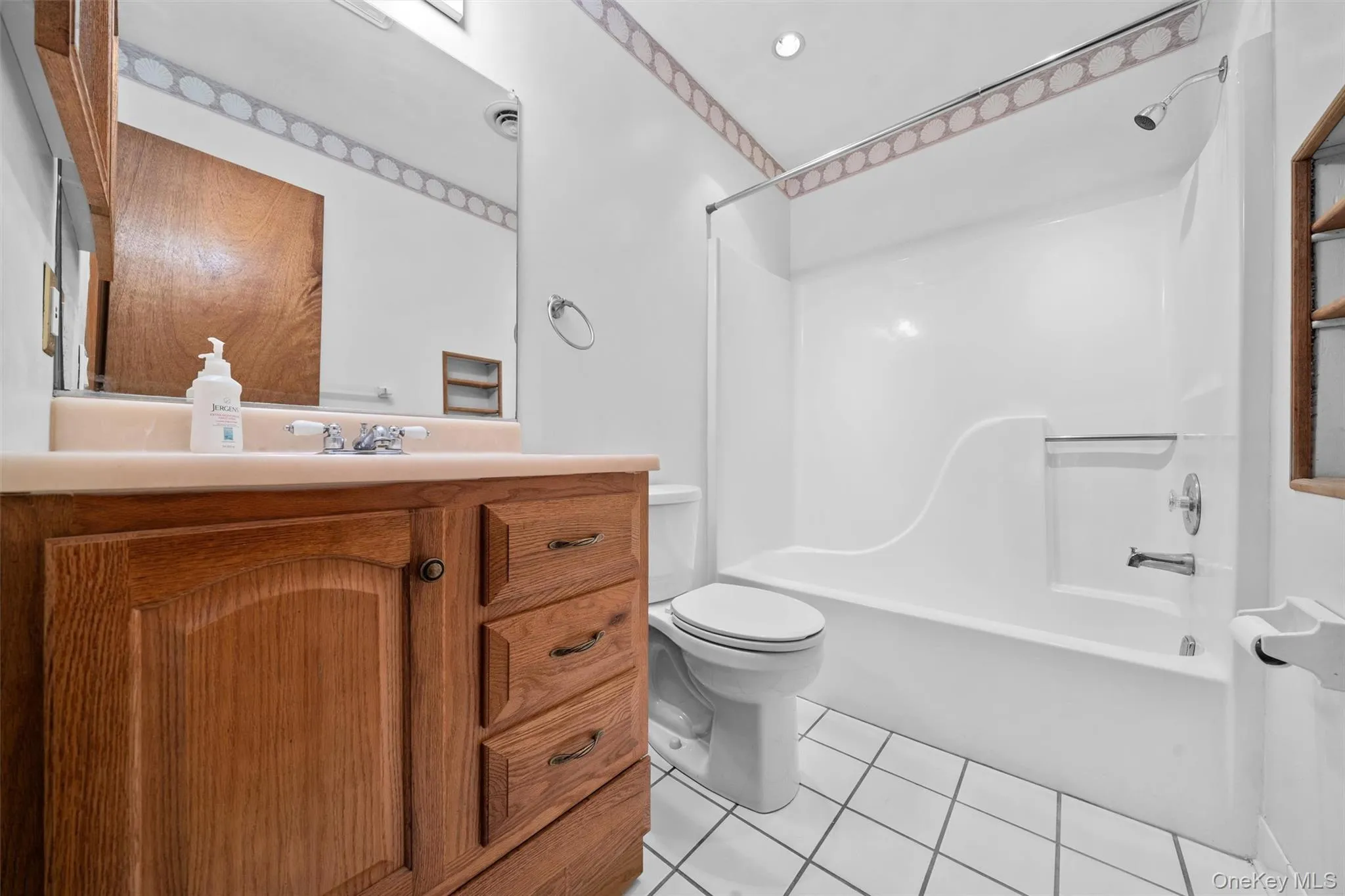Full guest bathroom with tile patterned floors, toilet, shower combination, and vanity Full guest bathroom with tile patterned floors, toilet, shower combination, and vanity