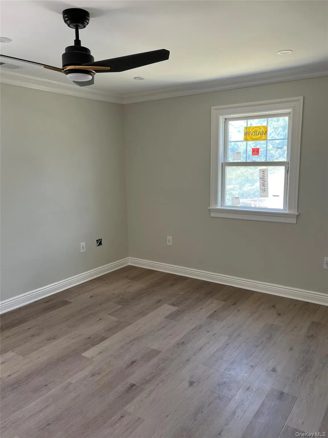 Empty room featuring ornamental molding, wood finished floors, and ceiling fan Empty room featuring ornamental molding, wood finished floors, and ceiling fan