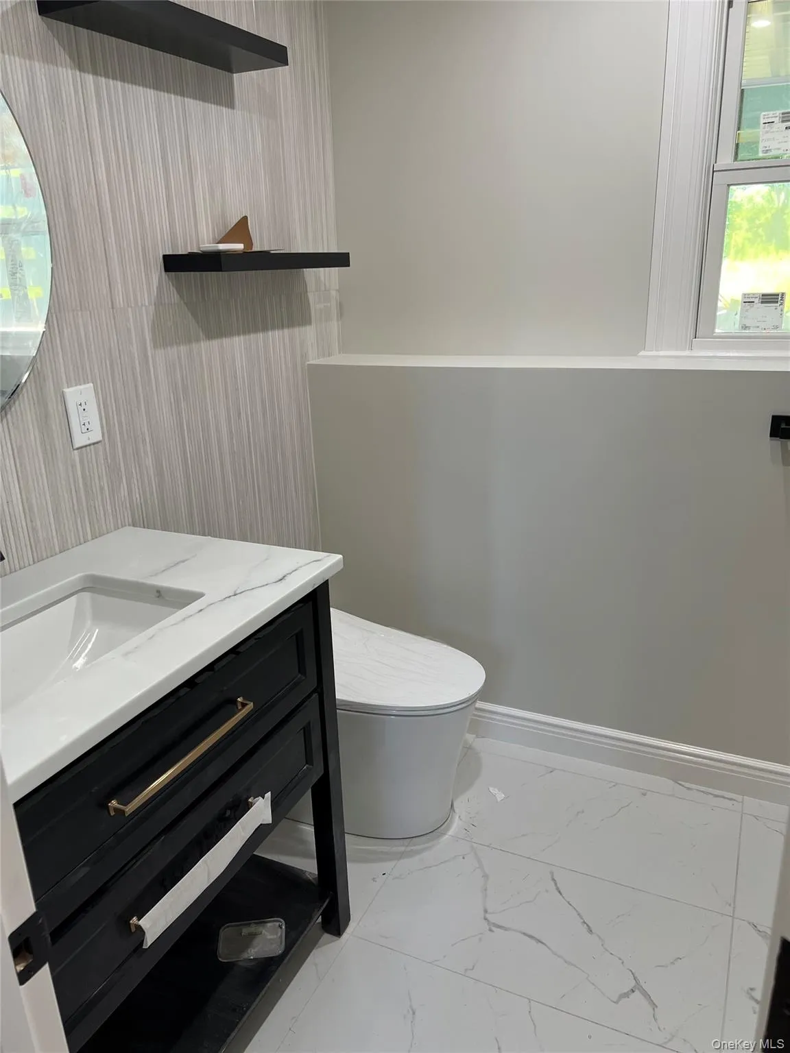 Bathroom featuring marble look tiles and vanity Bathroom featuring marble look tiles and vanity
