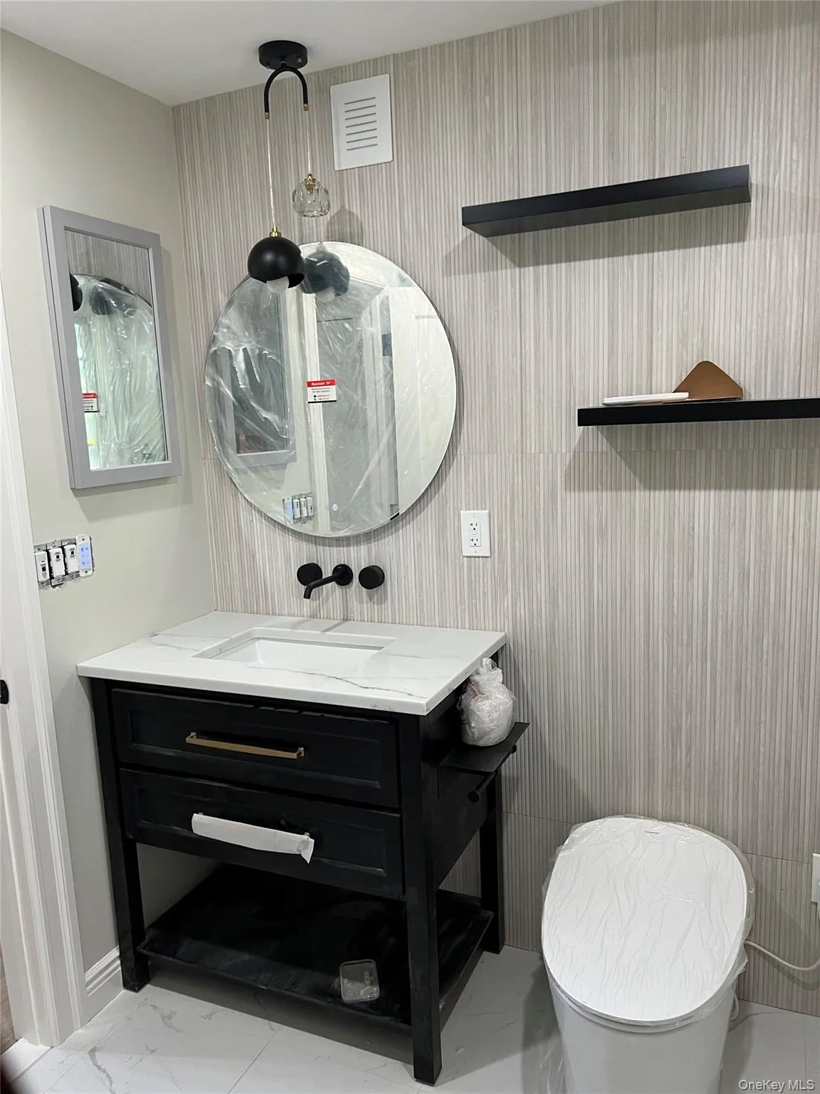 Half bathroom featuring vanity and marble finish flooring Half bathroom featuring vanity and marble finish flooring