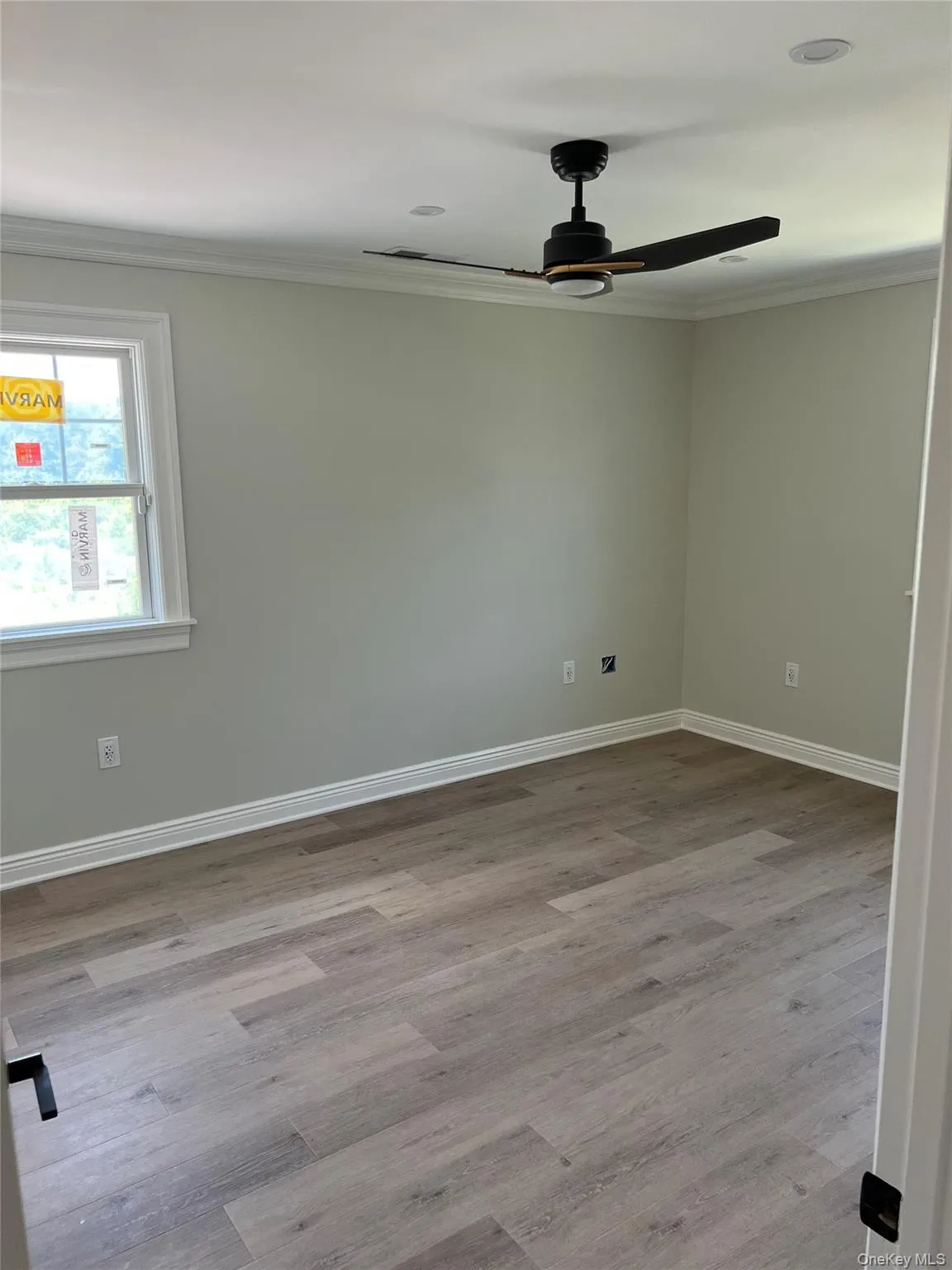 Empty room featuring ornamental molding, a ceiling fan, and wood finished floors Empty room featuring ornamental molding, a ceiling fan, and wood finished floors