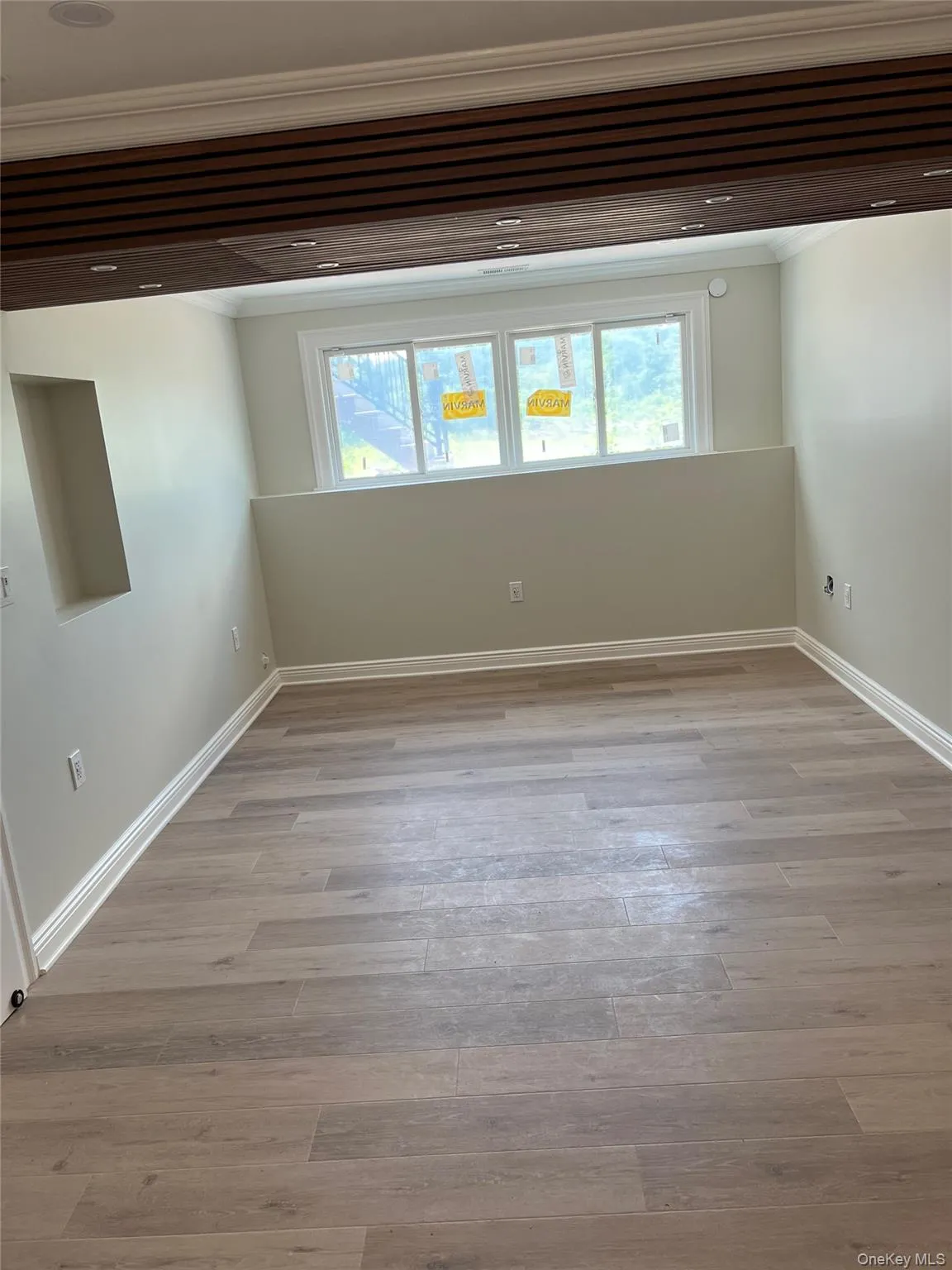 Unfurnished room with crown molding, healthy amount of natural light, and light wood-style floors Unfurnished room with crown molding, healthy amount of natural light, and light wood-style floors