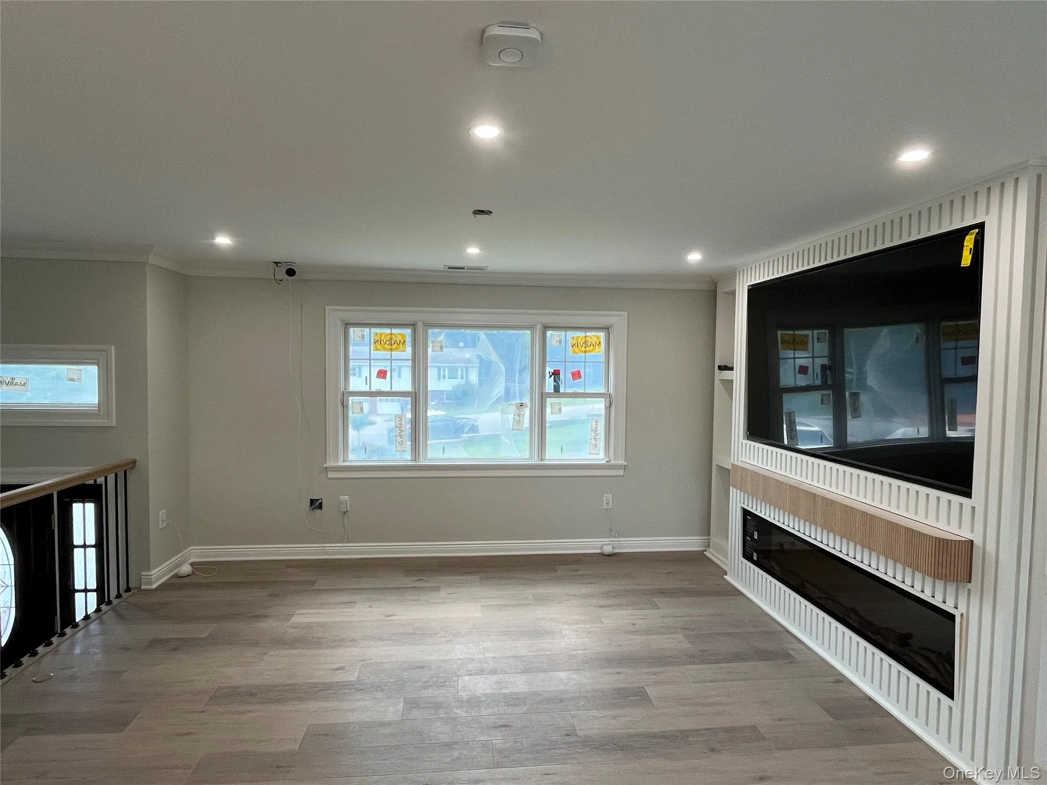 Unfurnished living room with crown molding, healthy amount of natural light, wood finished floors, recessed lighting, and a fireplace Unfurnished living room with crown molding, healthy amount of natural light, wood finished floors, recessed lighting, and a fireplace