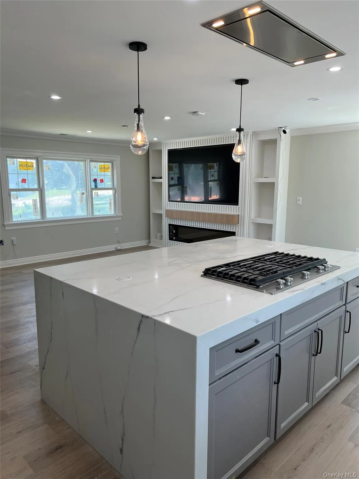 Kitchen featuring stainless steel gas cooktop, light wood-style flooring, gray cabinetry, hanging light fixtures, and recessed lighting Kitchen featuring stainless steel gas cooktop, light wood-style flooring, gray cabinetry, hanging light fixtures, and recessed lighting