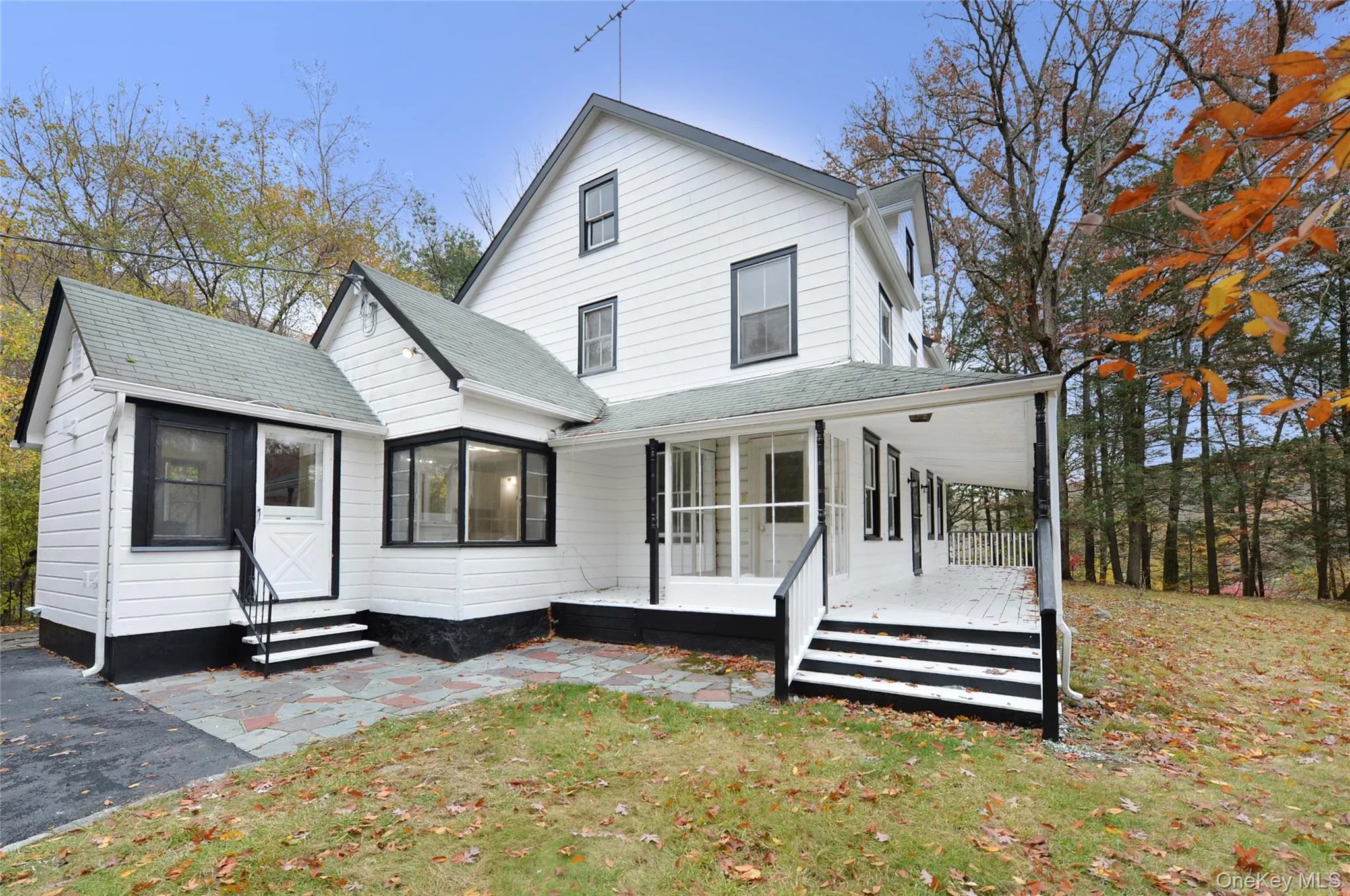Rear view of property featuring a lawn and roof with shingles Rear view of property featuring a lawn and roof with shingles