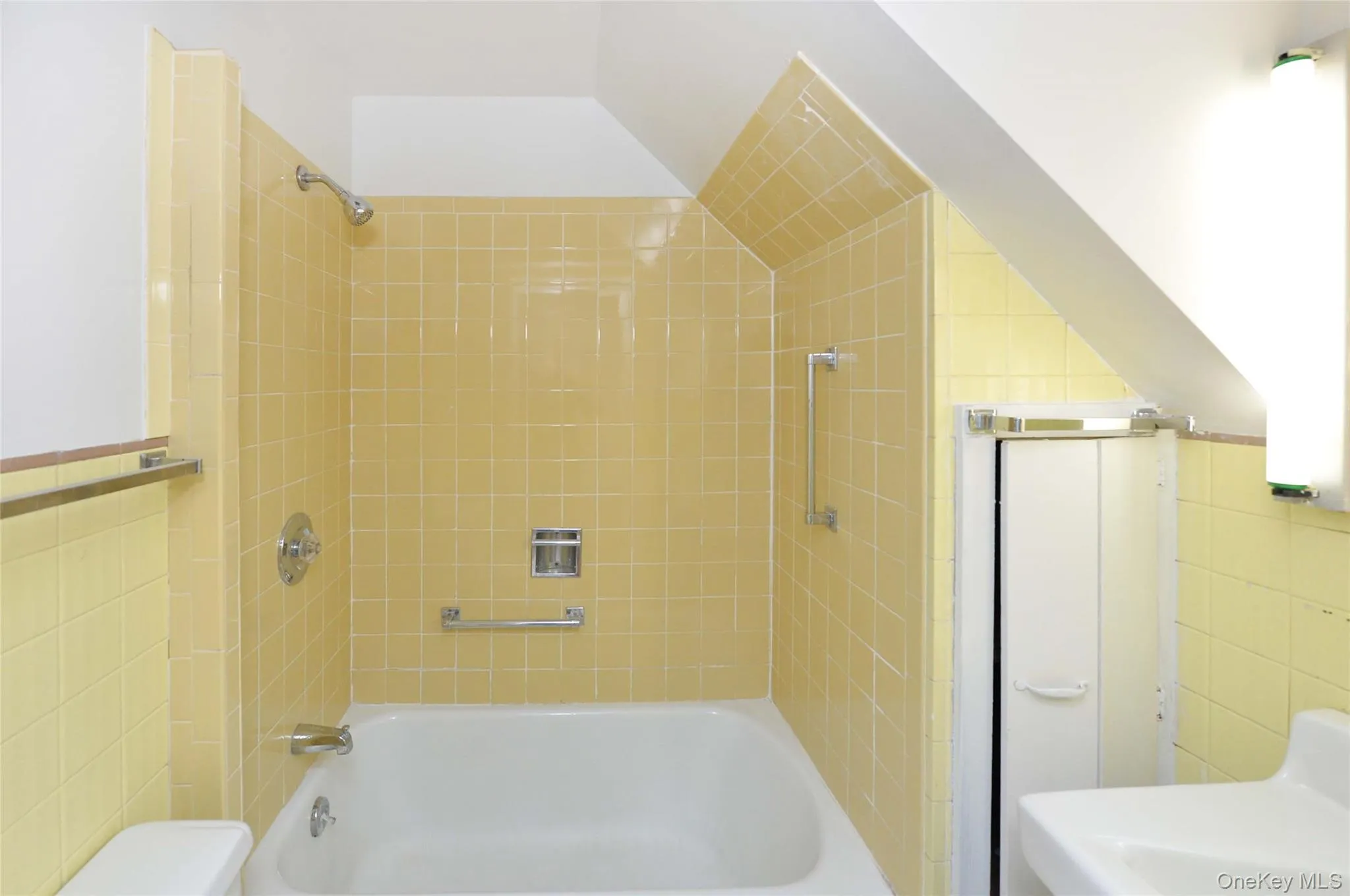 Full bath with tile walls, washtub / shower combination, and lofted ceiling Full bath with tile walls, washtub / shower combination, and lofted ceiling