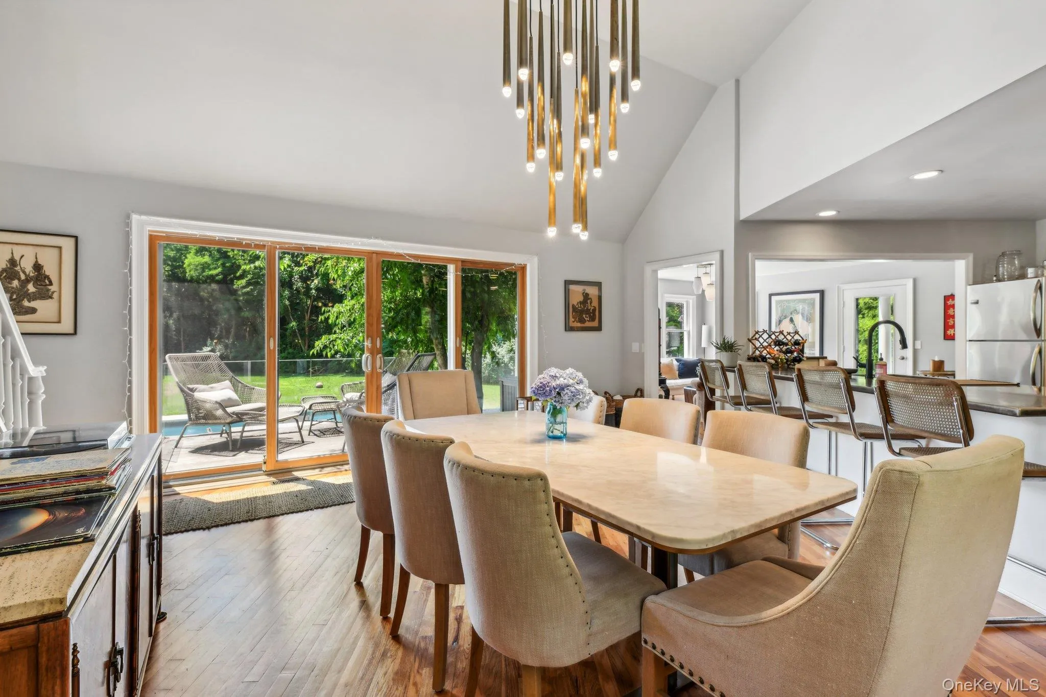 Dining room with wood finished floors, vaulted ceiling, and a chandelier Dining room with wood finished floors, vaulted ceiling, and a chandelier
