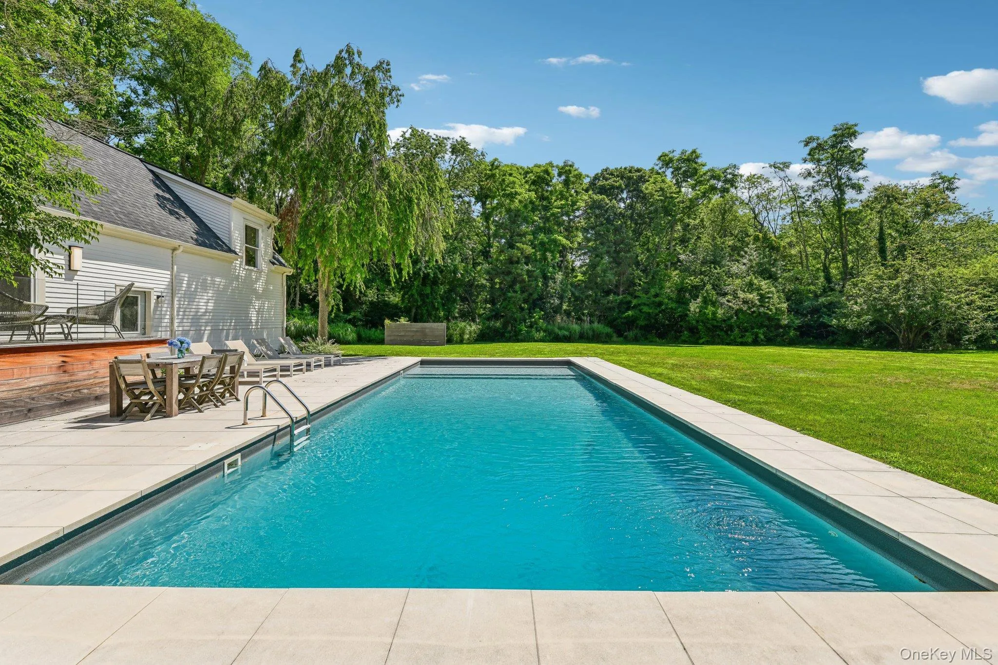 Outdoor pool featuring a patio area, a lawn, and outdoor dining area Outdoor pool featuring a patio area, a lawn, and outdoor dining area