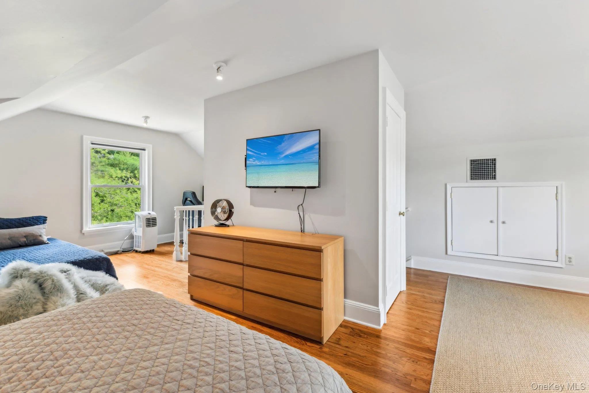 Bedroom with light wood finished floors and vaulted ceiling Bedroom with light wood finished floors and vaulted ceiling