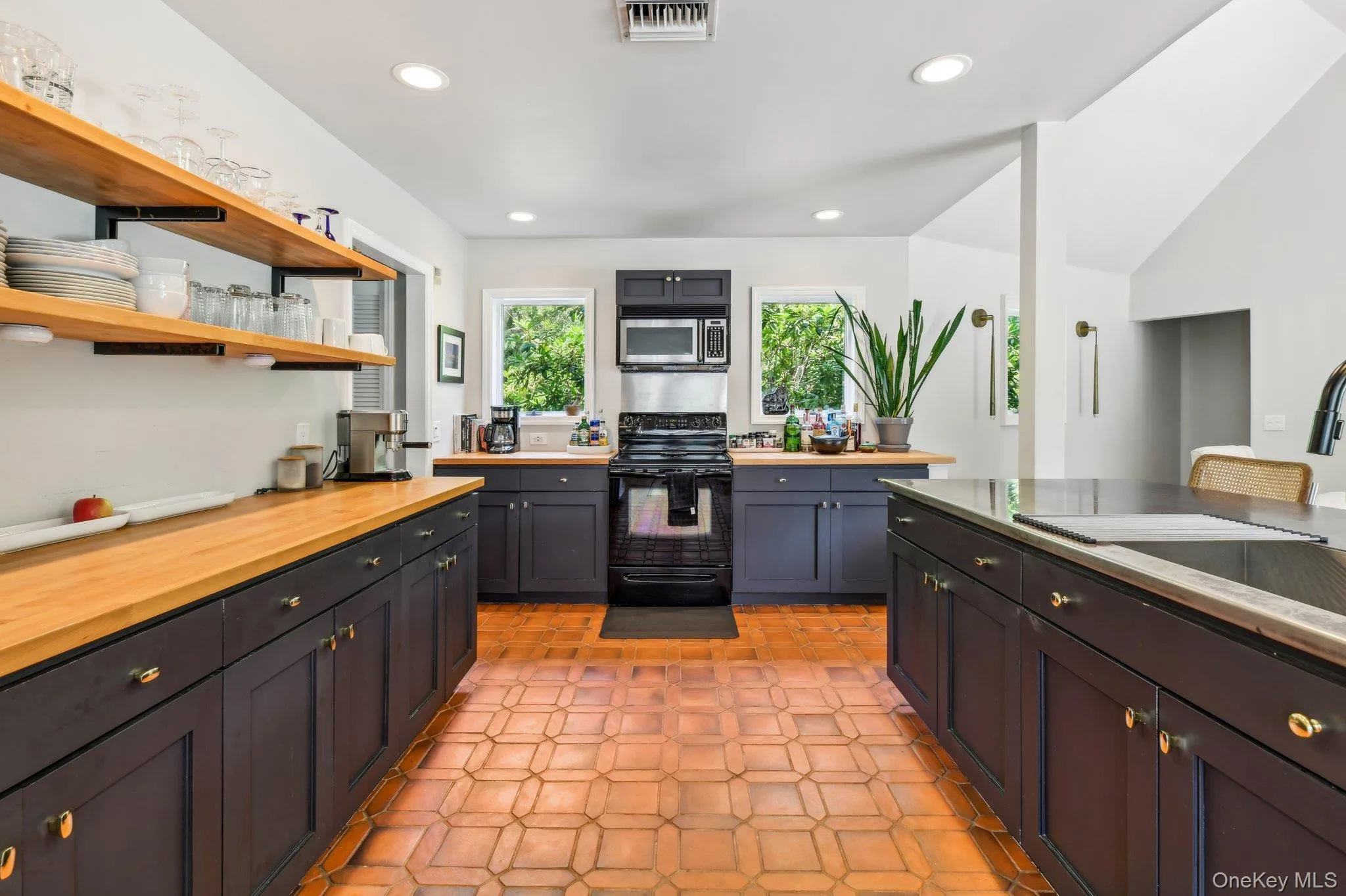 Kitchen featuring black range oven, wooden counters, recessed lighting, stainless steel microwave, and open shelves Kitchen featuring black range oven, wooden counters, recessed lighting, stainless steel microwave, and open shelves