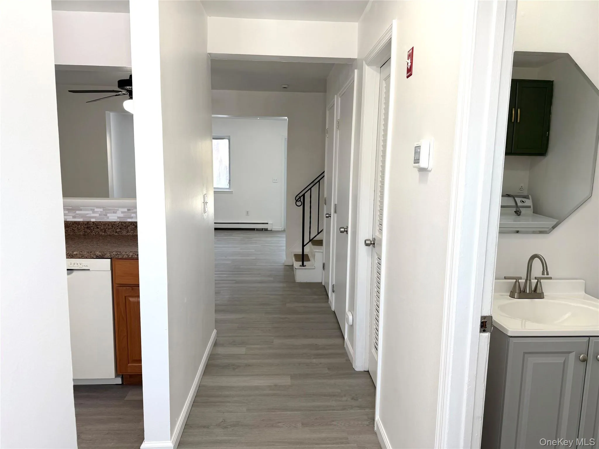 Corridor with light wood-style floors and baseboard heating Corridor with light wood-style floors and baseboard heating