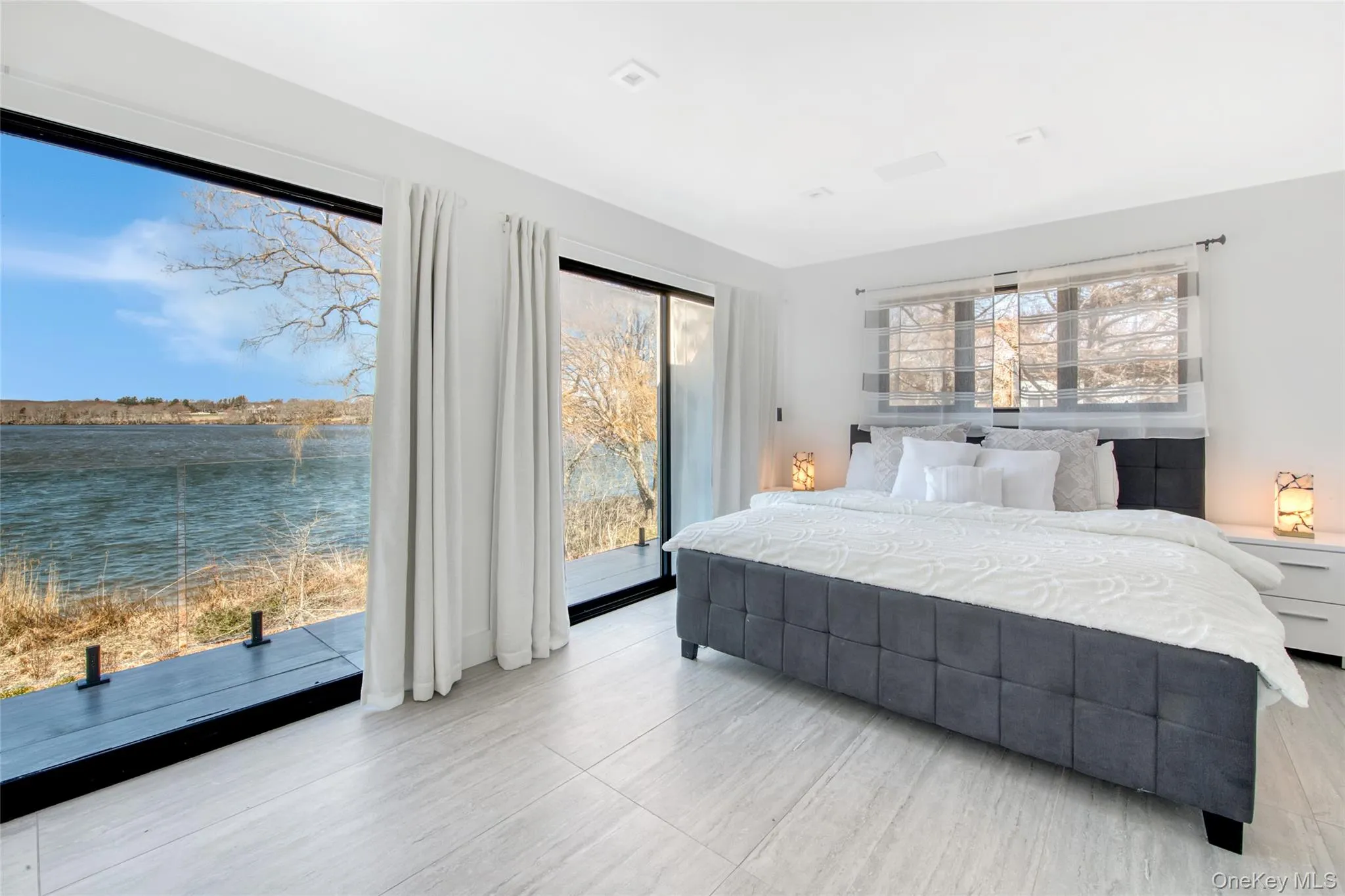 Bedroom featuring a water view and access to exterior Bedroom featuring a water view and access to exterior