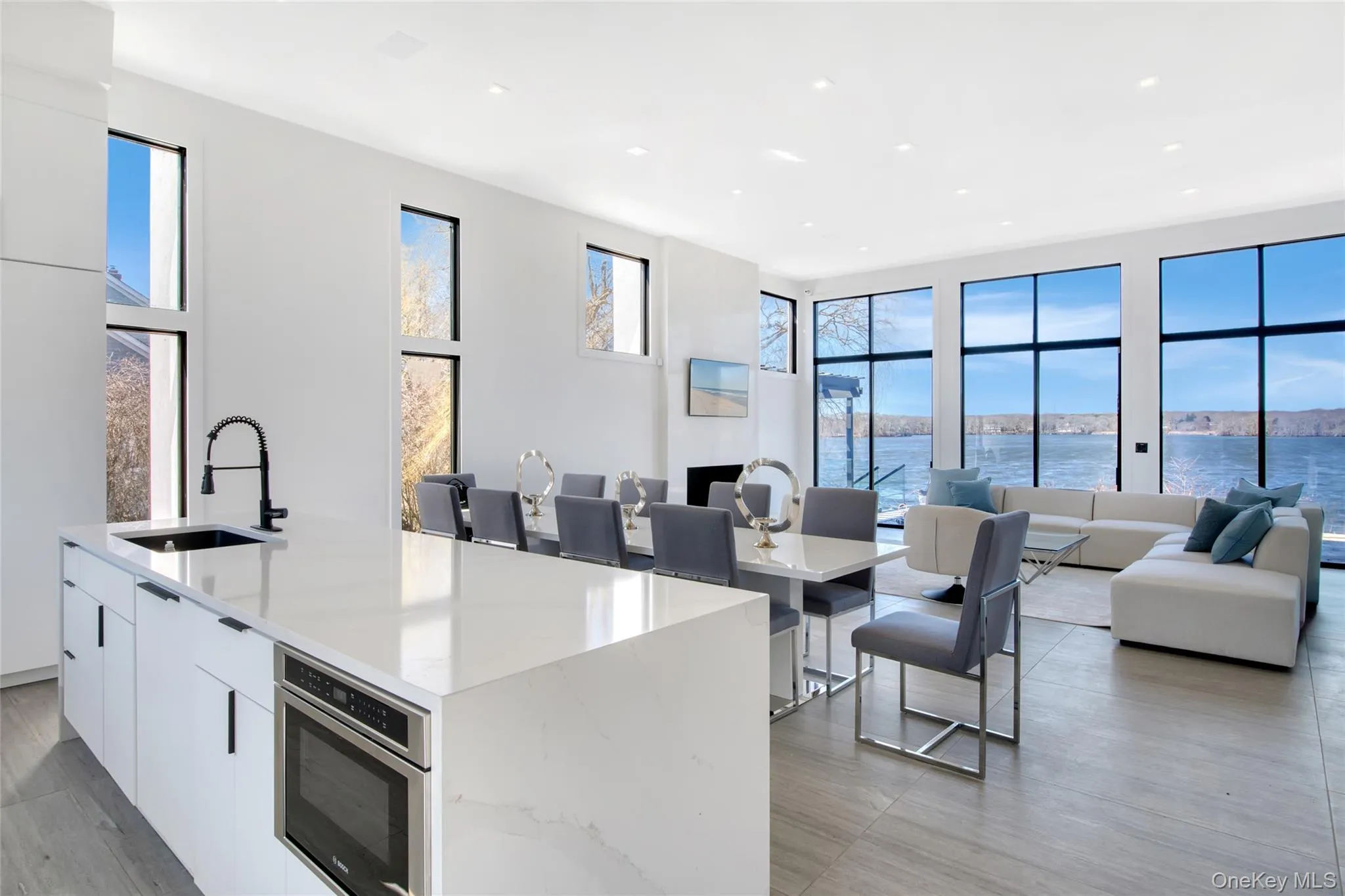 Kitchen featuring white cabinetry, modern cabinets, a sink, and open floor plan Kitchen featuring white cabinetry, modern cabinets, a sink, and open floor plan