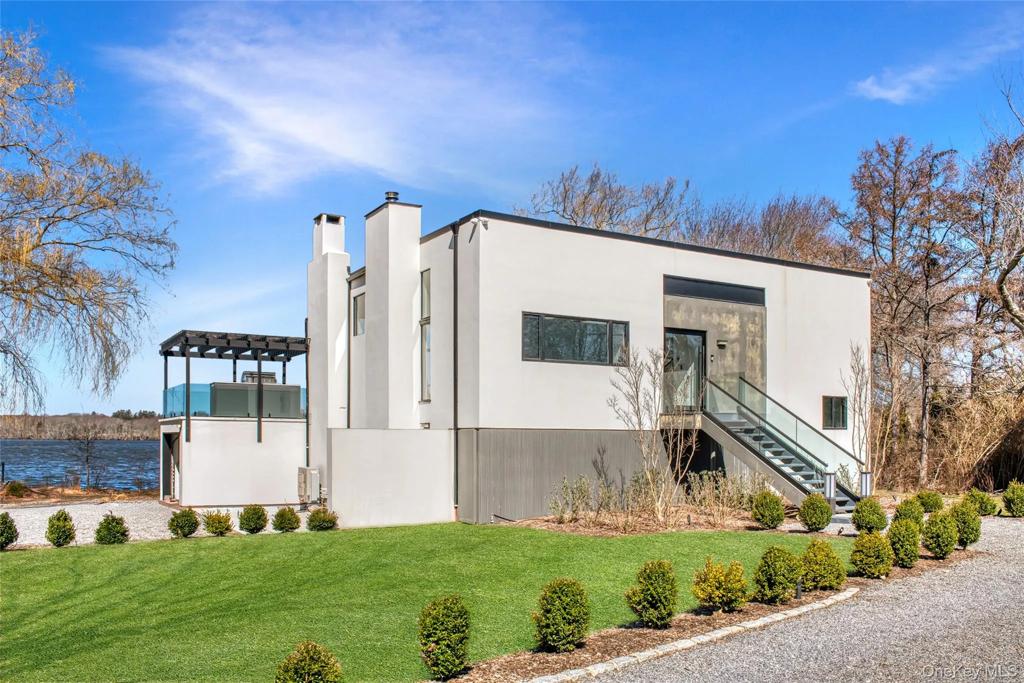 View of property exterior with a pergola, a lawn, and a water view View of property exterior with a pergola, a lawn, and a water view
