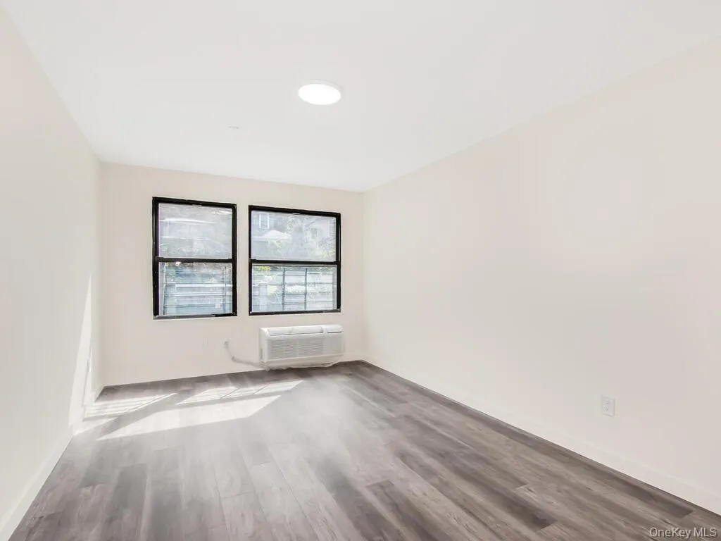 Spare room with wood finished floors and a wall unit AC Spare room with wood finished floors and a wall unit AC