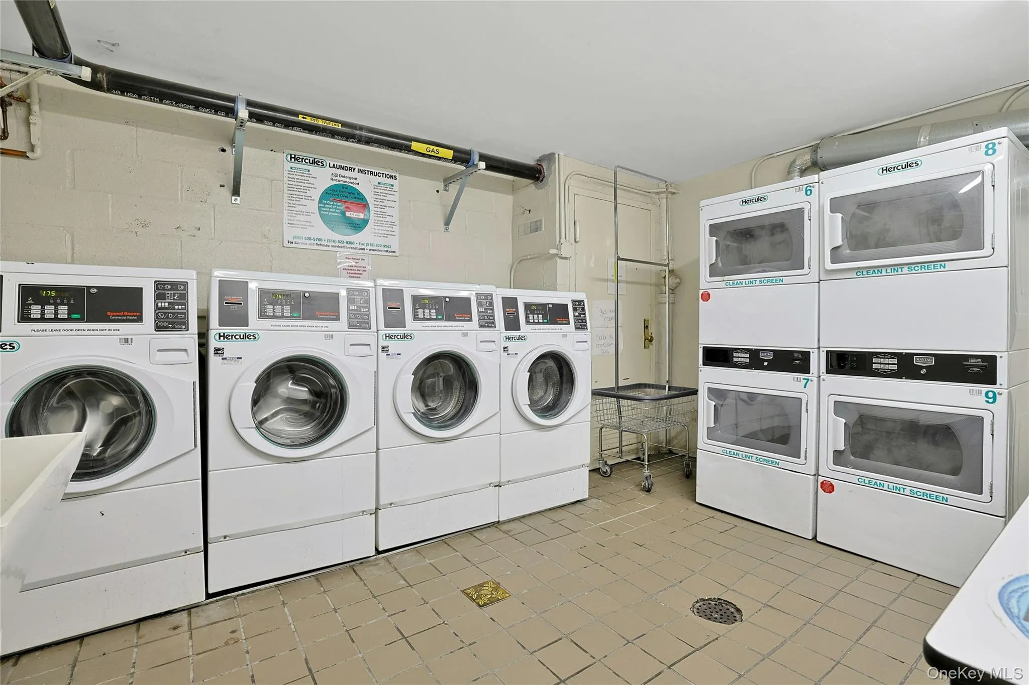 Communal laundry room featuring washer and stacked clothes dryer Communal laundry room featuring washer and stacked clothes dryer