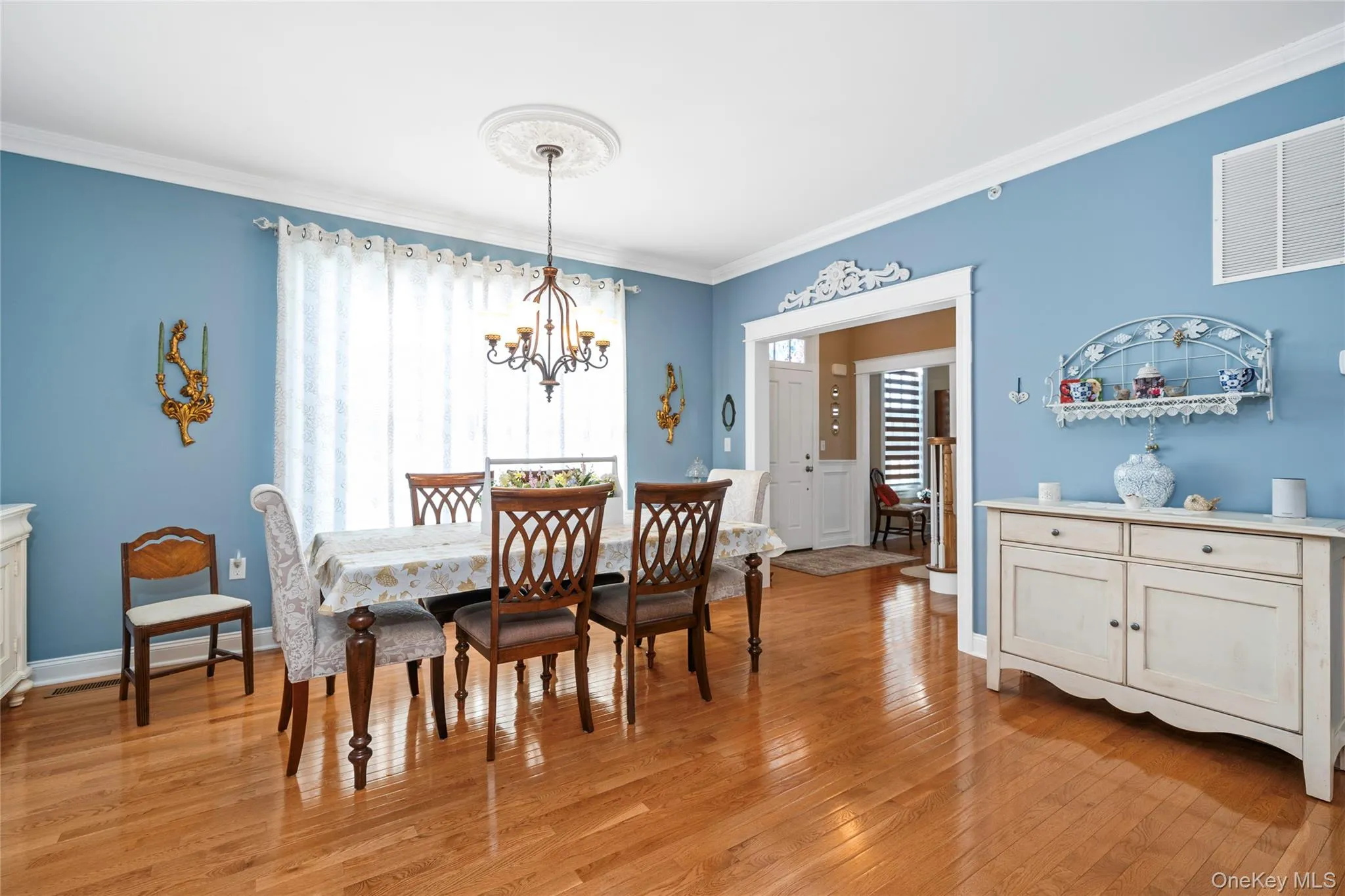 Dining room with light wood-style flooring, crown molding, and a chandelier Dining room with light wood-style flooring, crown molding, and a chandelier