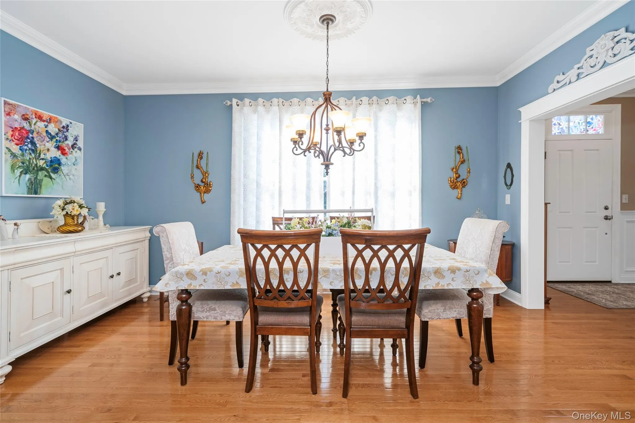 Dining space with ornamental molding, hanging lights, and light wood finished floors Dining space with ornamental molding, hanging lights, and light wood finished floors