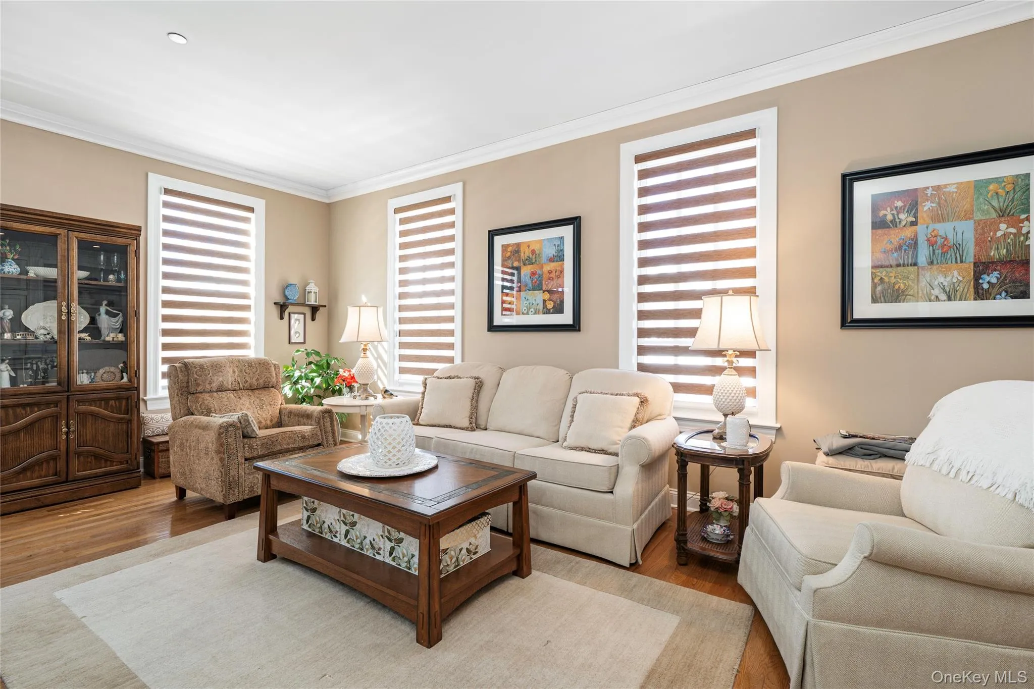 Living area featuring wood finished floors and crown molding Living area featuring wood finished floors and crown molding
