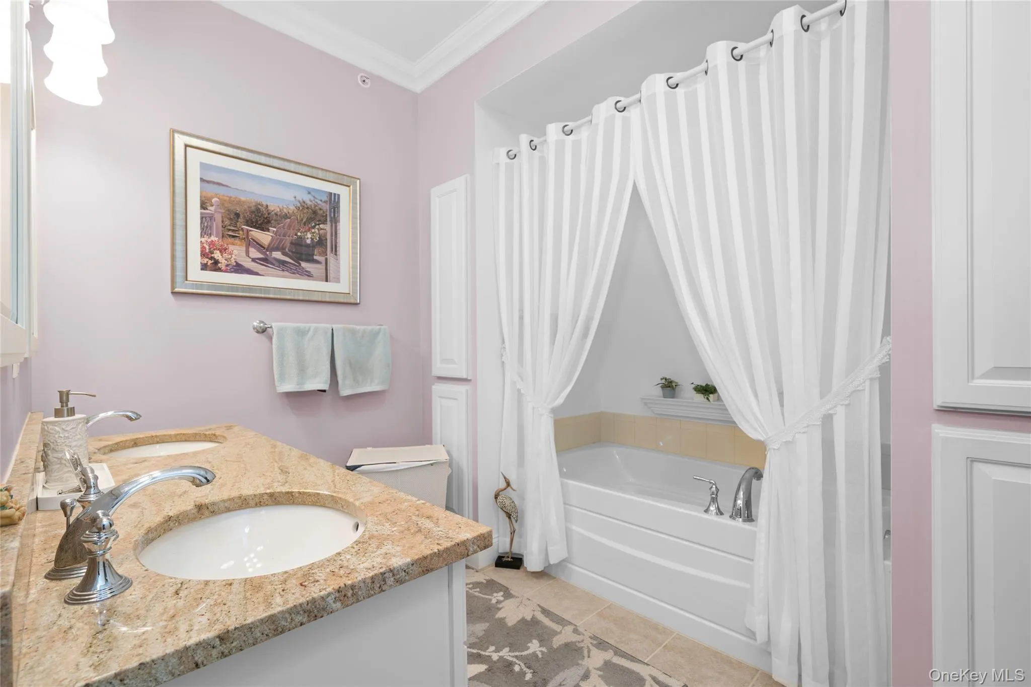 Master Bathroom featuring crown molding, double vanity, light tile patterned floors, and shower / bath combo with shower curtain Master Bathroom featuring crown molding, double vanity, light tile patterned floors, and shower / bath combo with shower curtain