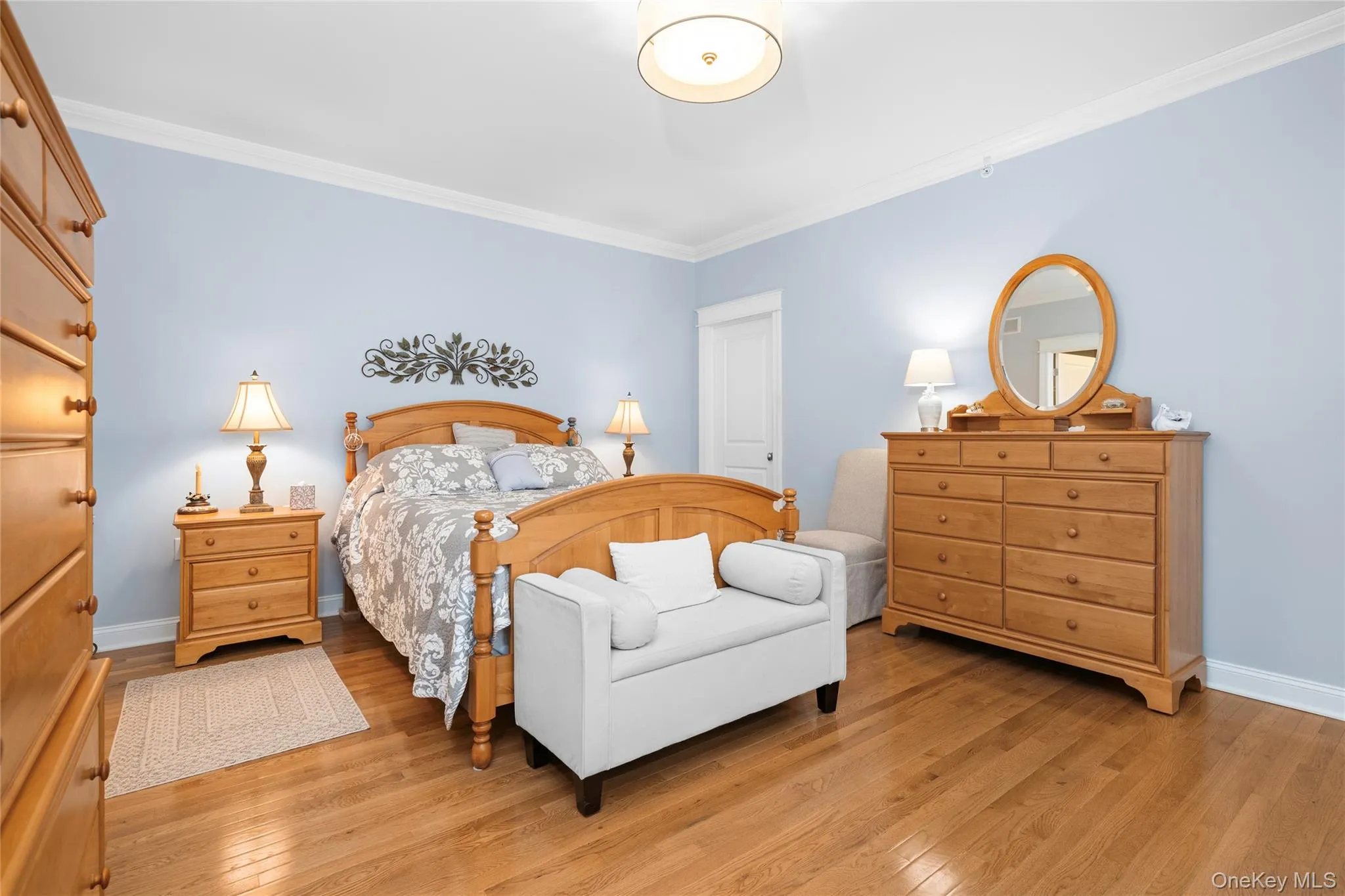 Bedroom with light wood-style flooring and ornamental molding Bedroom with light wood-style flooring and ornamental molding