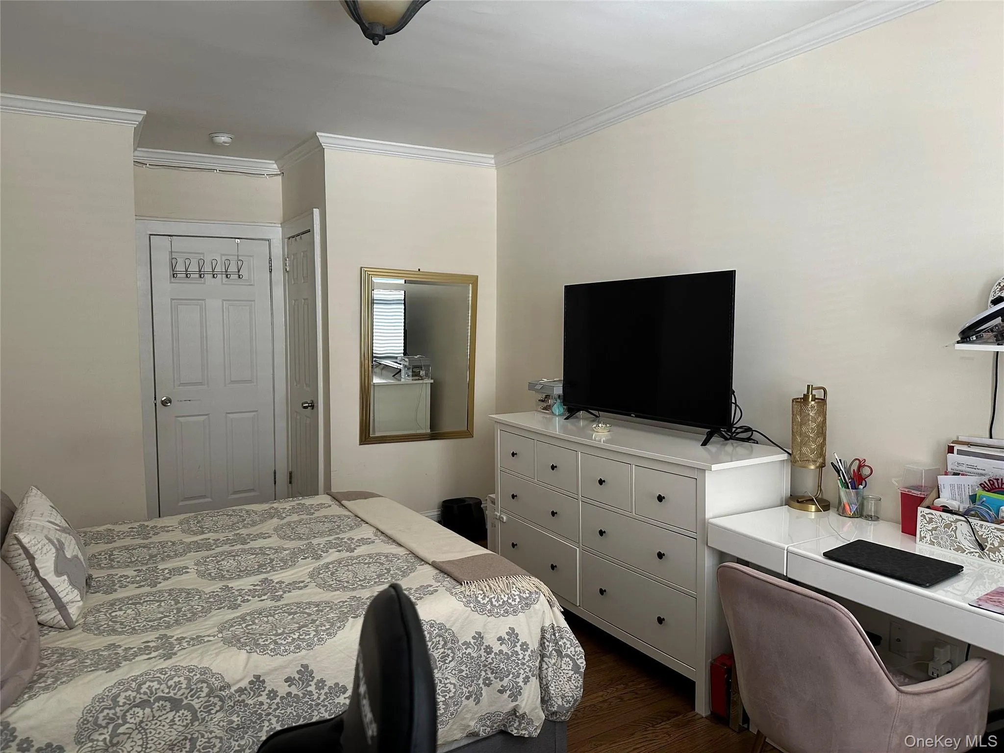 Bedroom featuring dark hardwood / wood-style flooring, a closet, and ornamental molding Bedroom featuring dark hardwood / wood-style flooring, a closet, and ornamental molding