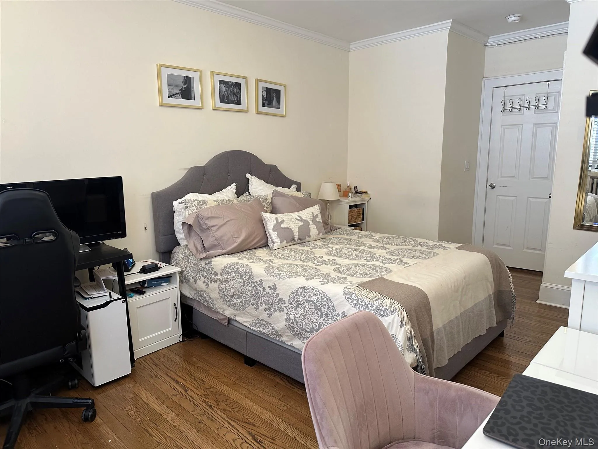 Bedroom featuring crown molding and dark wood-type flooring Bedroom featuring crown molding and dark wood-type flooring