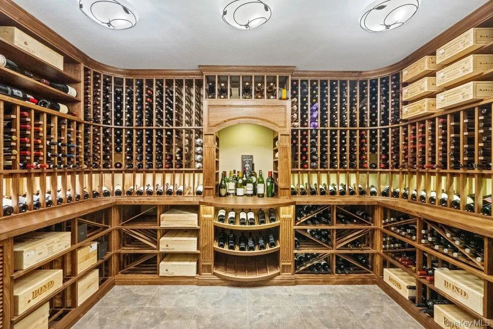 View of temperature controlled custom wine room with floor to ceiling shelving View of temperature controlled custom wine room with floor to ceiling shelving