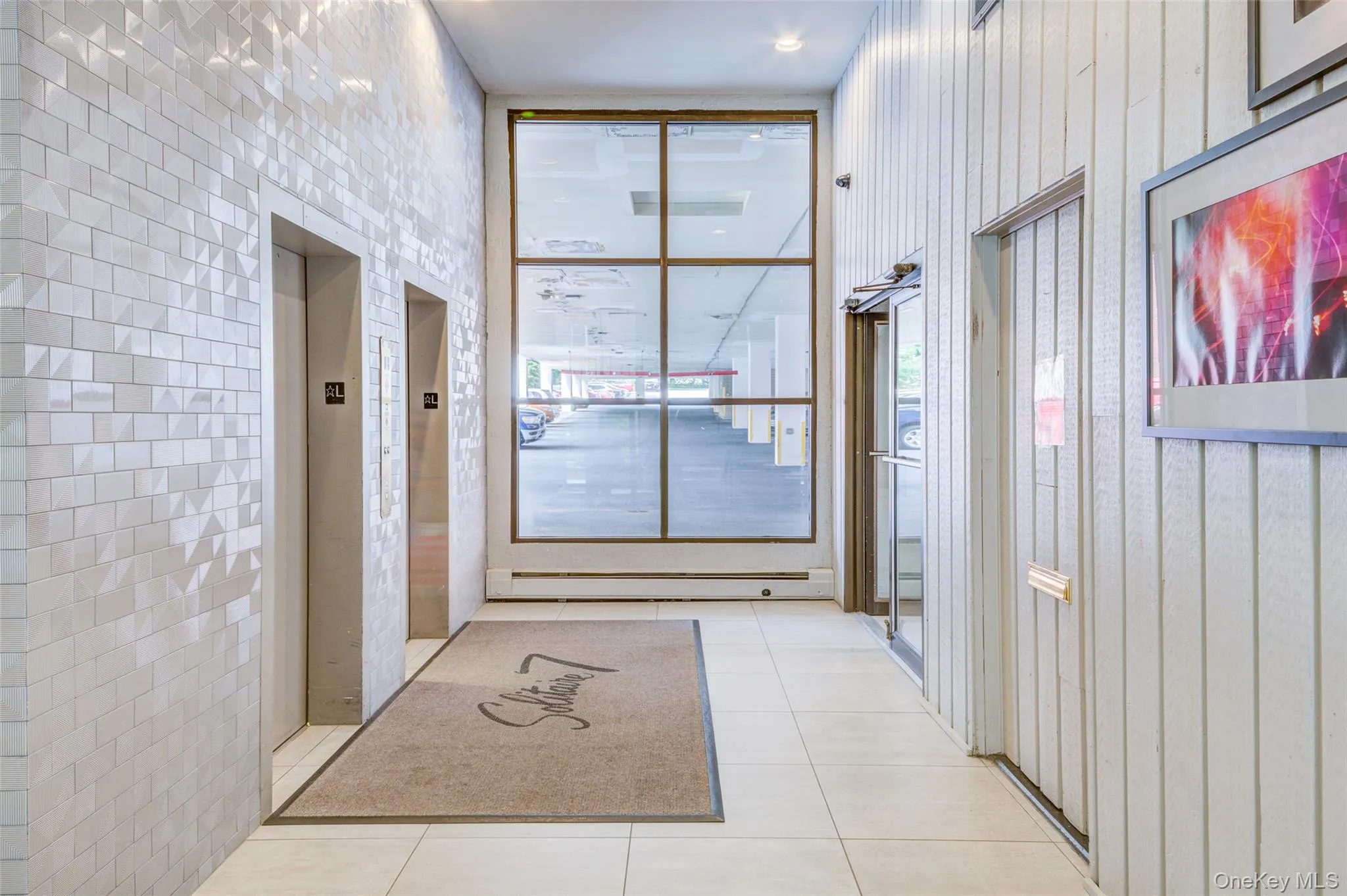 Corridor featuring tile patterned flooring and elevator Corridor featuring tile patterned flooring and elevator