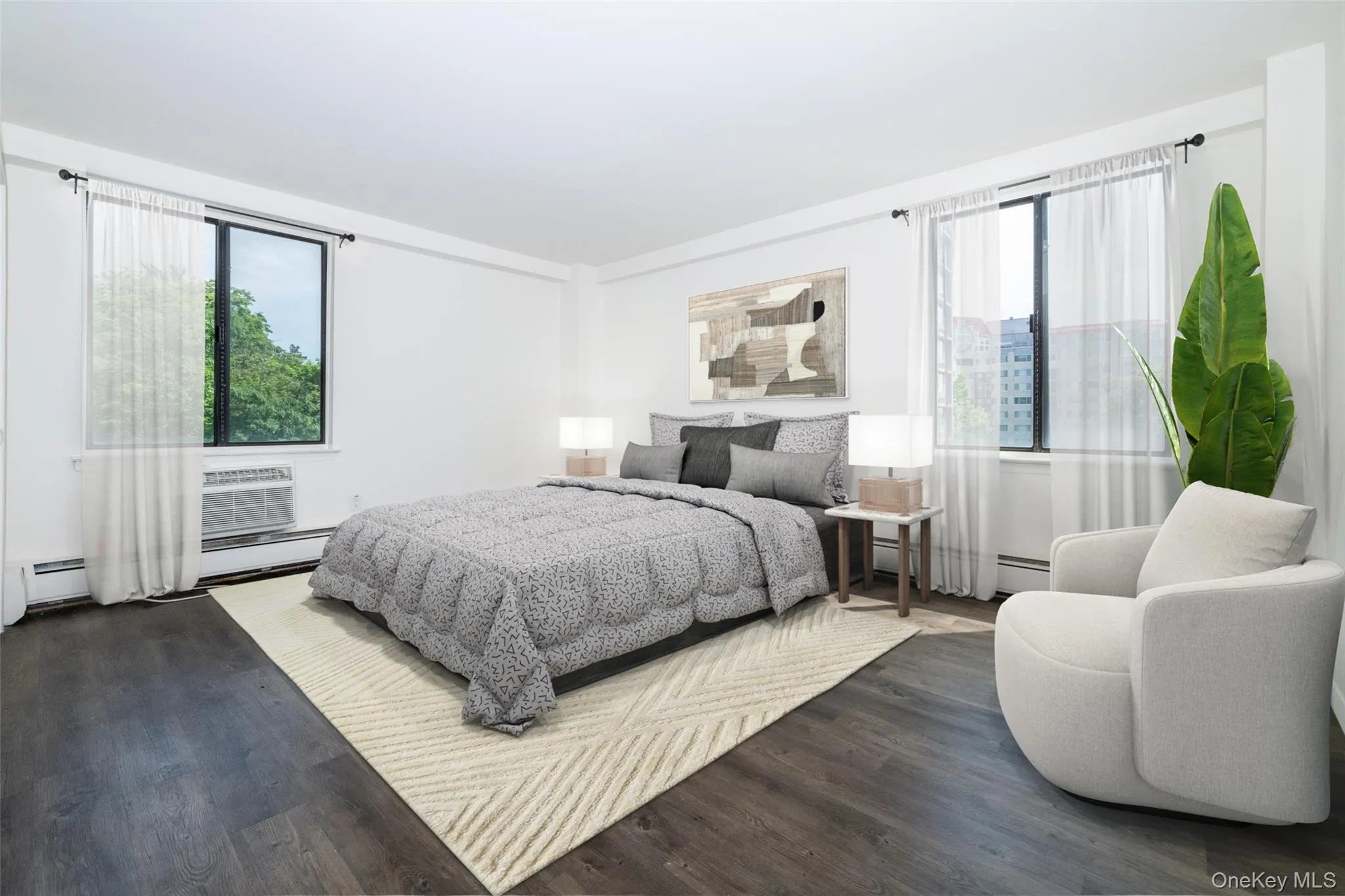 Bedroom with wood finished floors, multiple windows, and a baseboard heating unit Bedroom with wood finished floors, multiple windows, and a baseboard heating unit