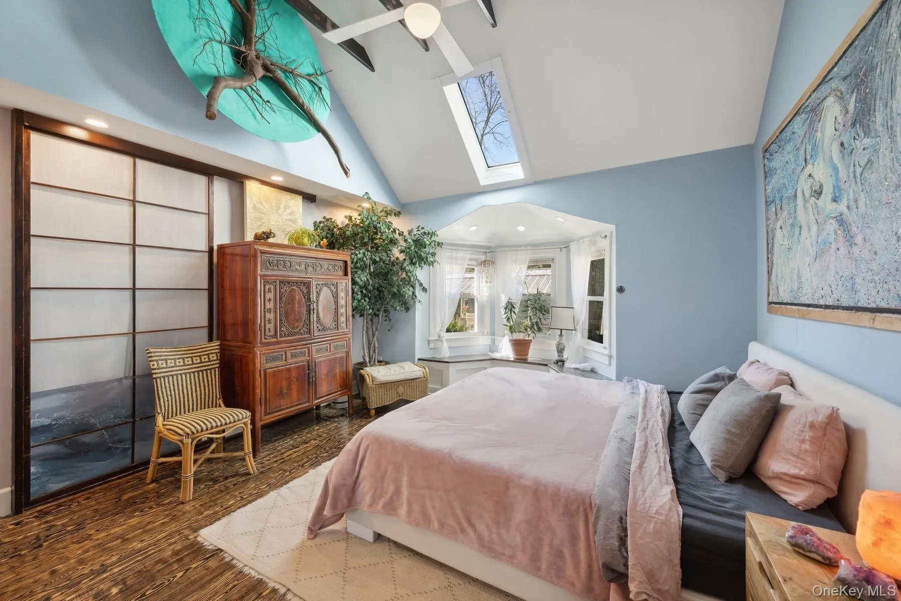 Bedroom with high vaulted ceiling, ceiling fan, a skylight, and hardwood / wood-style floors Bedroom with high vaulted ceiling, ceiling fan, a skylight, and hardwood / wood-style floors