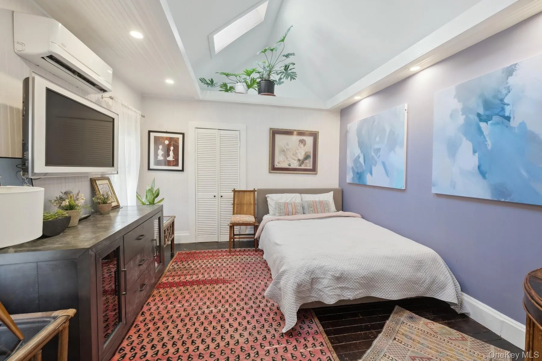 Bedroom with a wall unit AC, a closet, and vaulted ceiling with skylight Bedroom with a wall unit AC, a closet, and vaulted ceiling with skylight