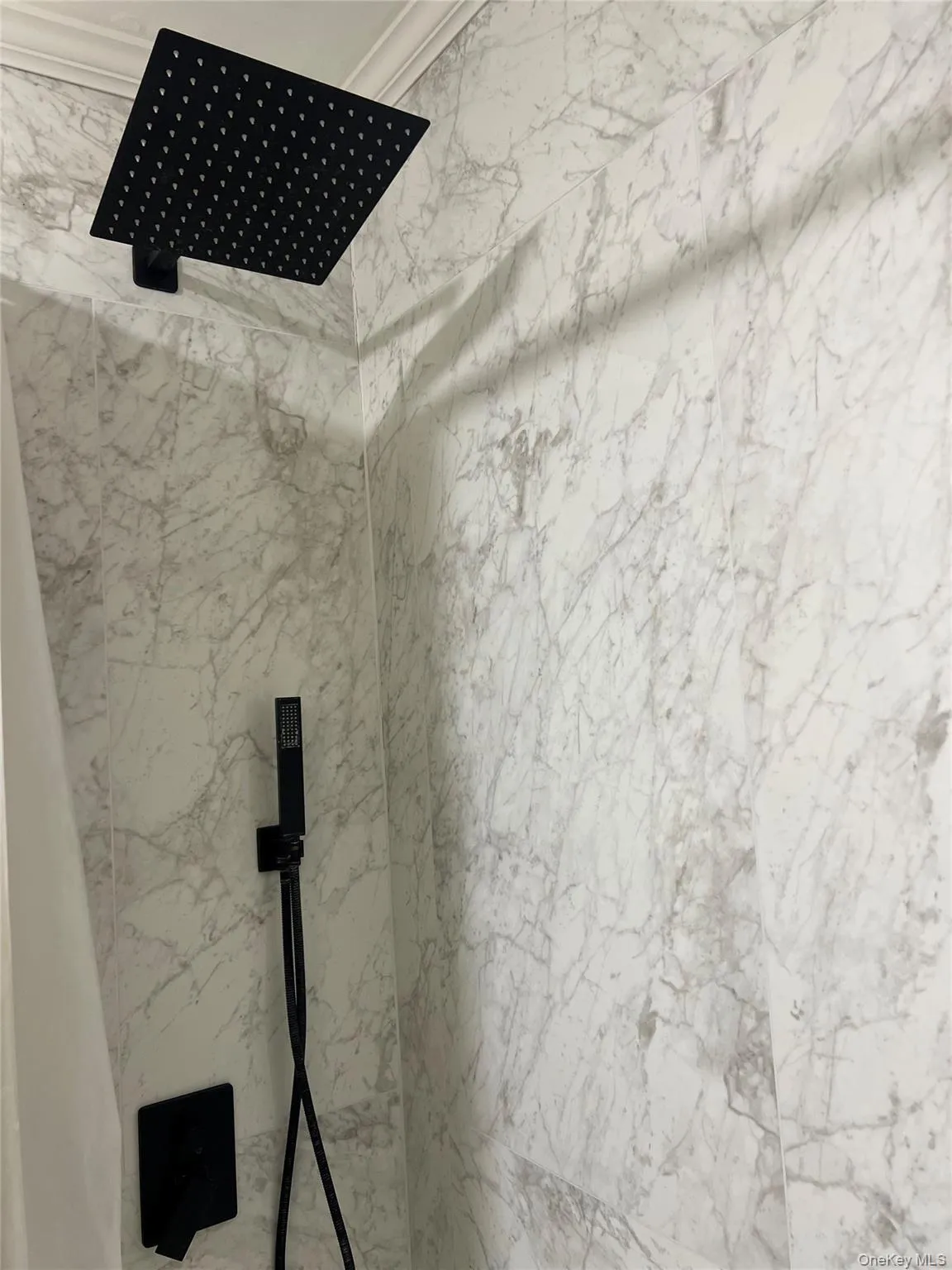 Renovated bathroom with new shower tile, rain head and handheld Renovated bathroom with new shower tile, rain head and handheld