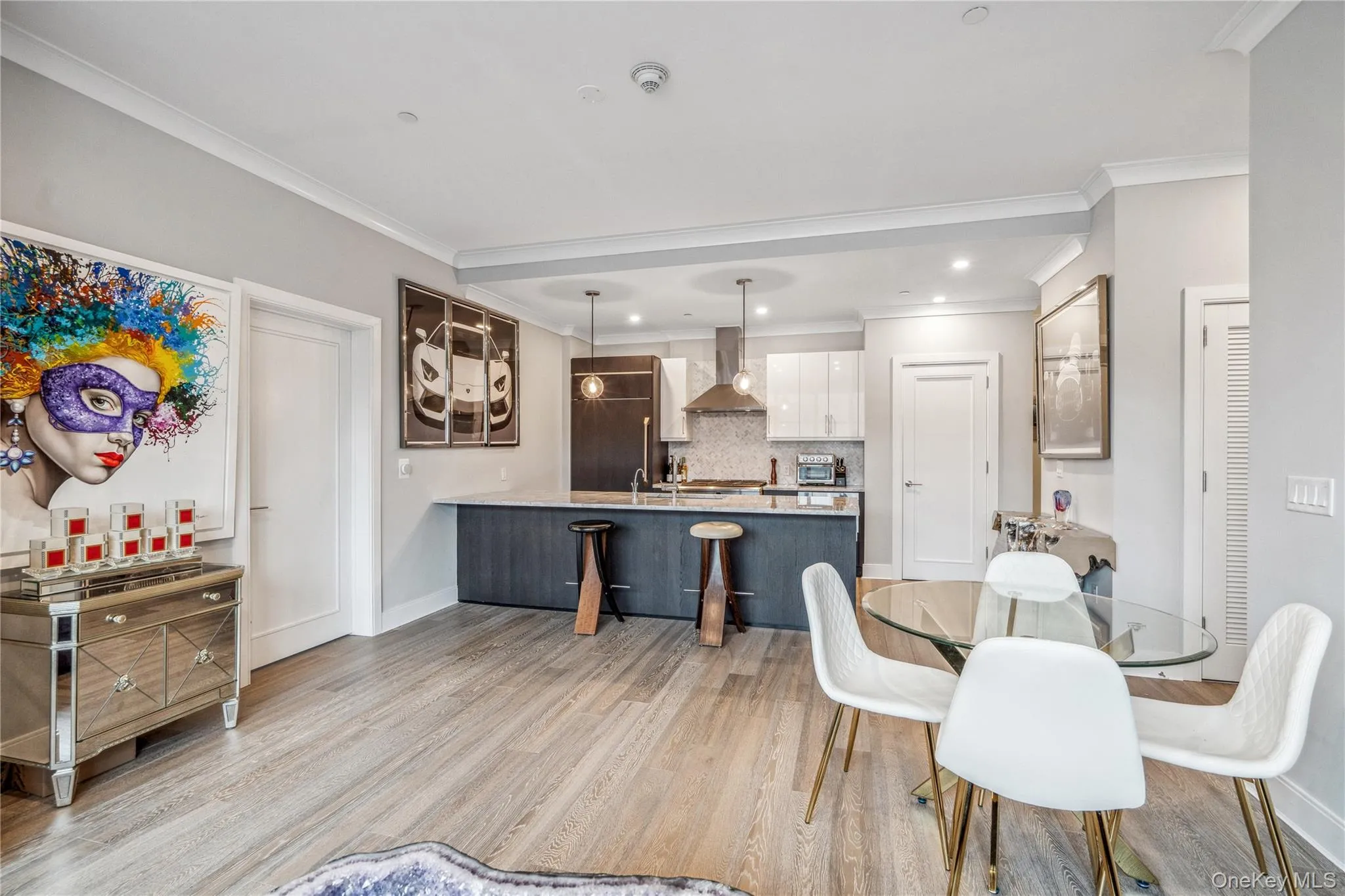 Dining room featuring light hardwood / wood-style floors and ornamental molding Dining room featuring light hardwood / wood-style floors and ornamental molding