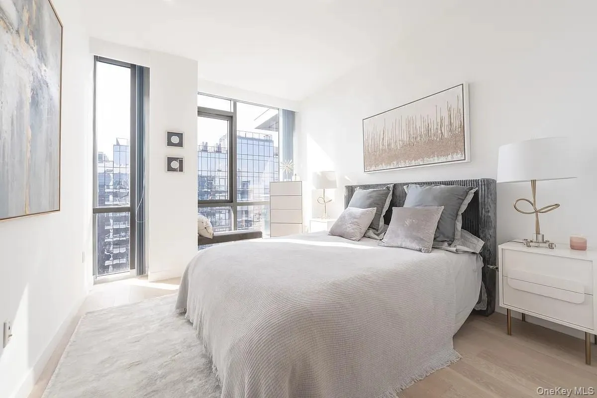 Bedroom featuring floor to ceiling windows and light wood-style floors Bedroom featuring floor to ceiling windows and light wood-style floors