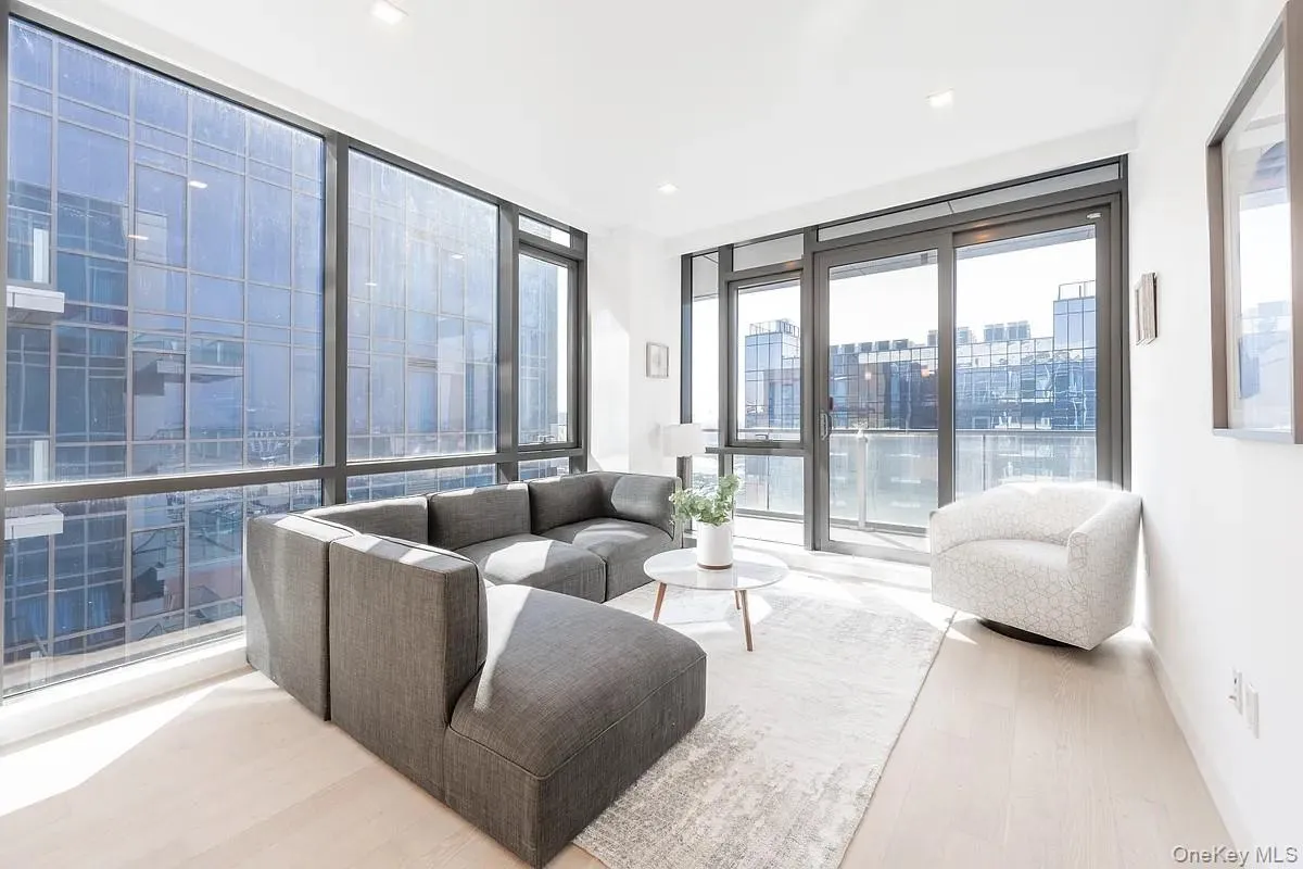 Living area with a view of city, wood finished floors, and floor to ceiling windows Living area with a view of city, wood finished floors, and floor to ceiling windows