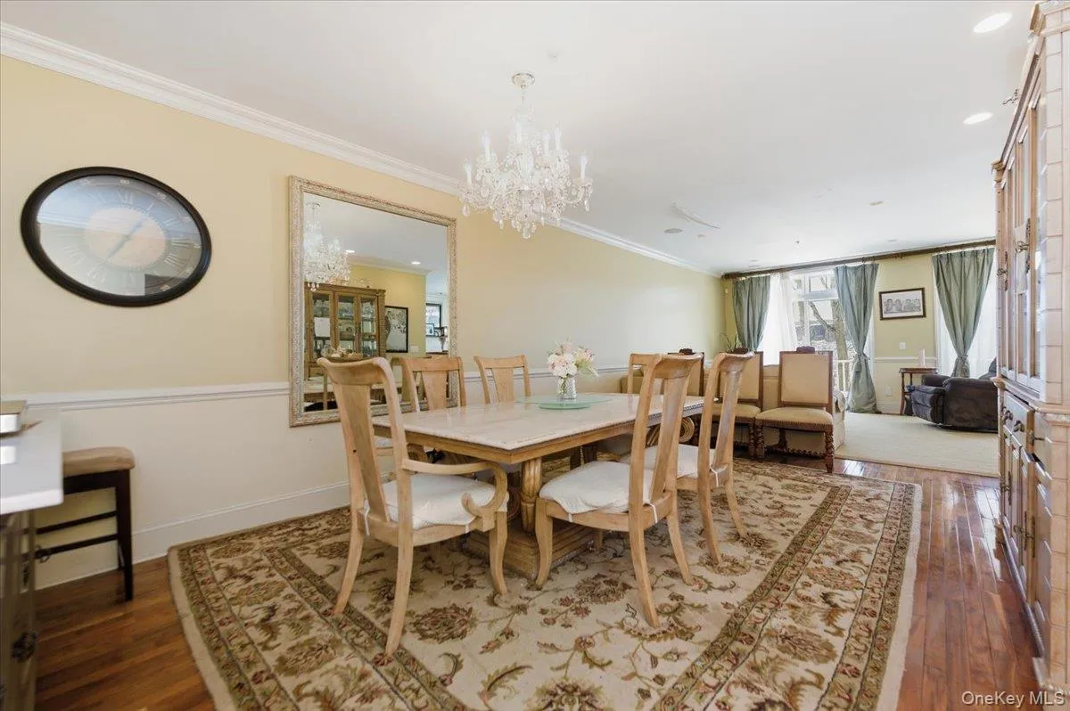 Dining space with dark wood finished floors, crown molding, and suspended lighting Dining space with dark wood finished floors, crown molding, and suspended lighting