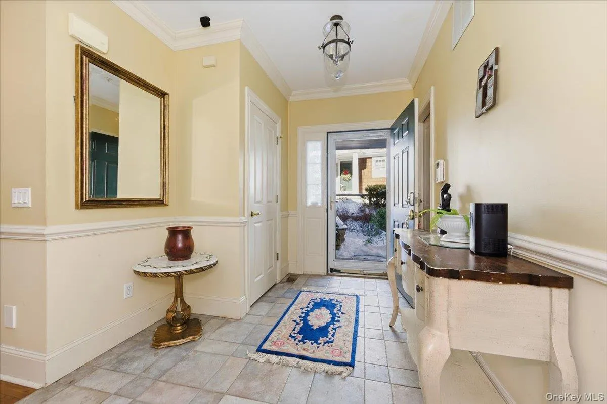 Foyer entrance featuring crown molding and baseboards Foyer entrance featuring crown molding and baseboards