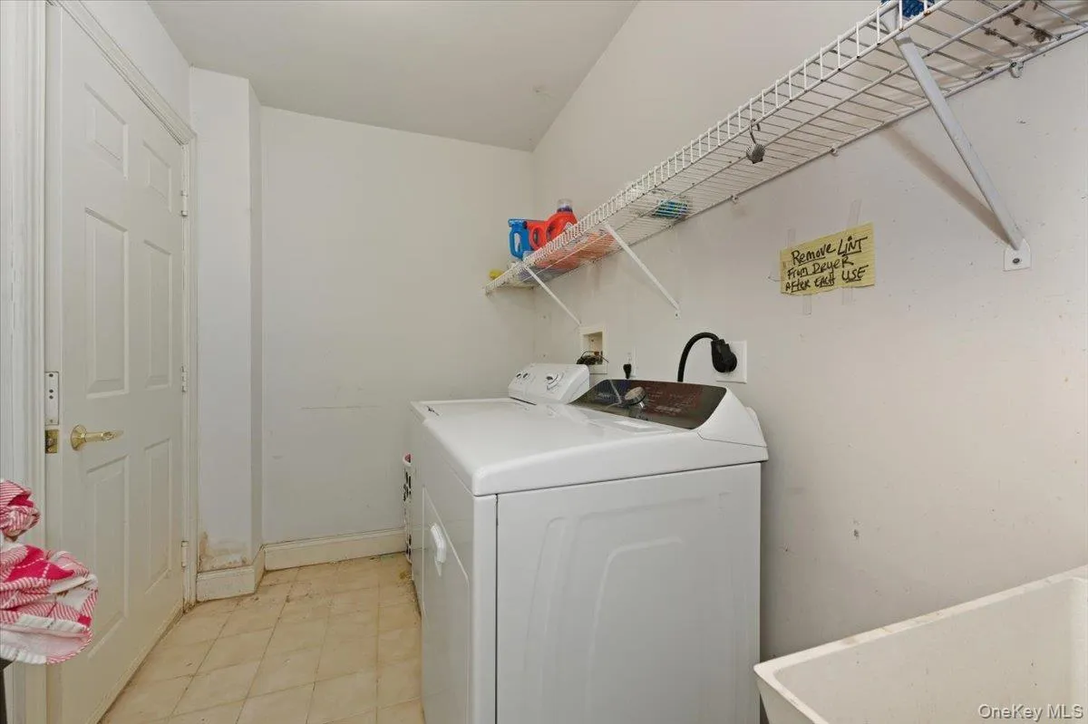 Laundry area featuring separate washer and dryer and slop sink Laundry area featuring separate washer and dryer and slop sink