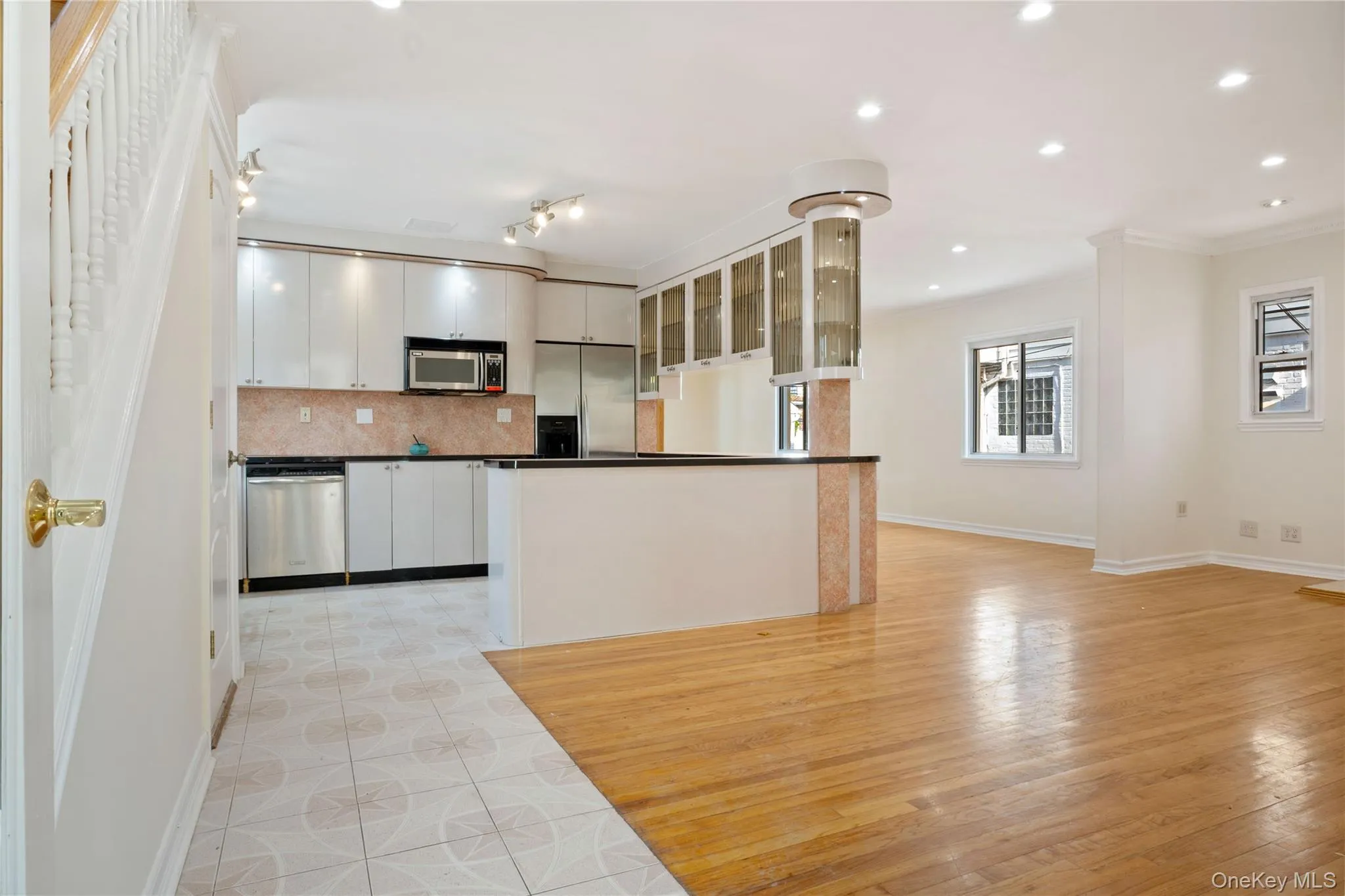 Kitchen with stainless steel appliances, dark countertops, baseboards, decorative backsplash, and white cabinetry Kitchen with stainless steel appliances, dark countertops, baseboards, decorative backsplash, and white cabinetry