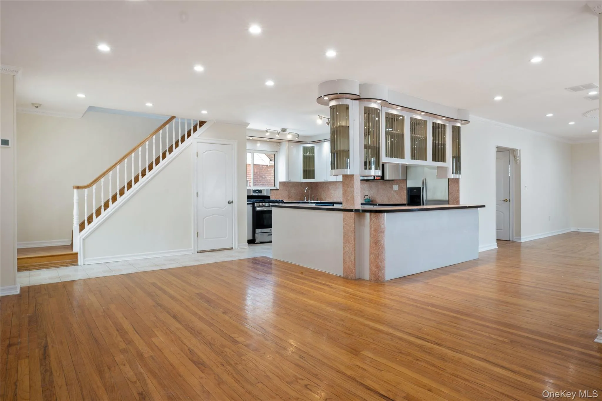 Kitchen featuring decorative backsplash, crown molding, dark countertops, baseboards, and stainless steel appliances Kitchen featuring decorative backsplash, crown molding, dark countertops, baseboards, and stainless steel appliances