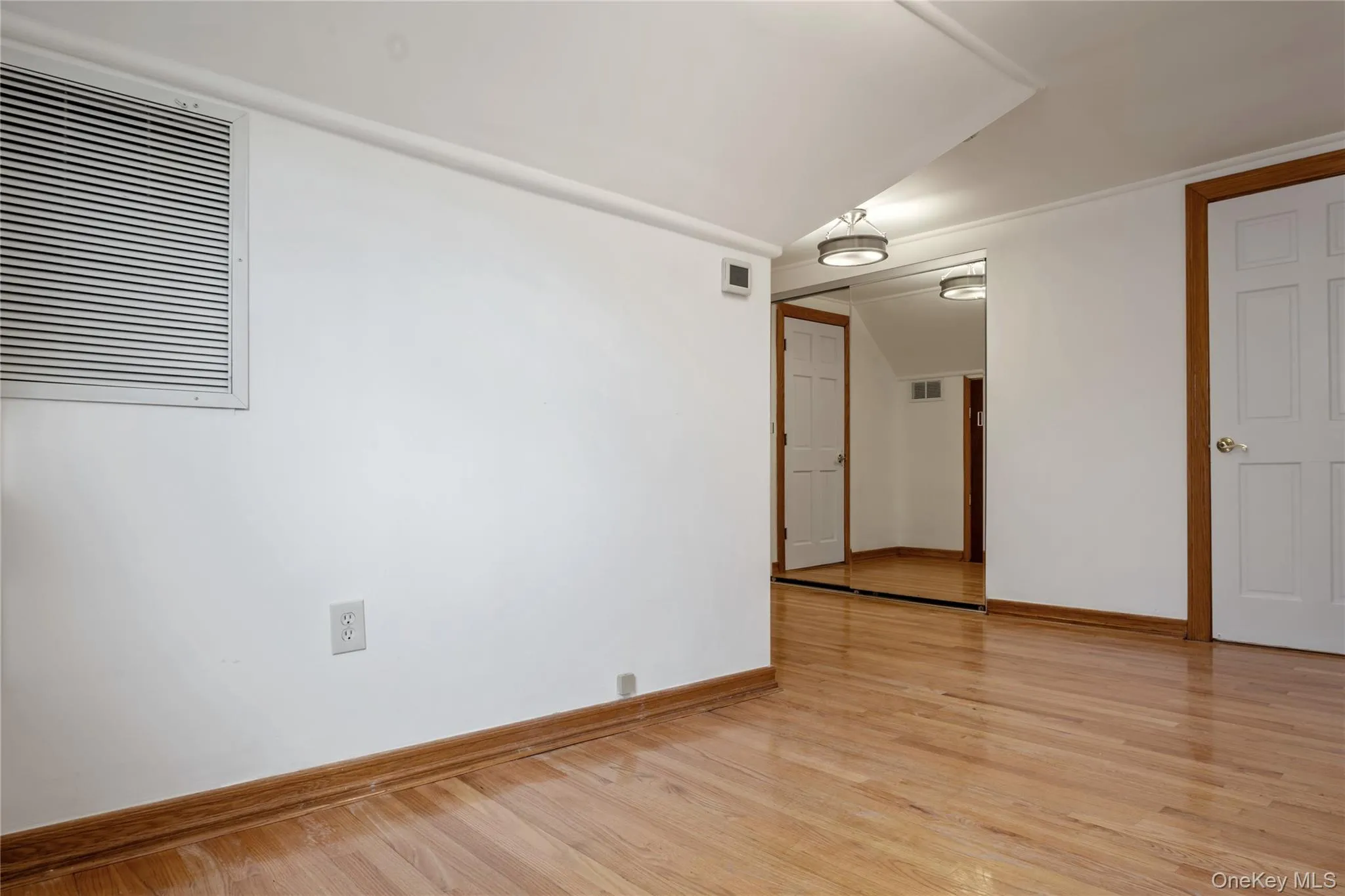 Spare room with light wood-type flooring, baseboards, and visible vents Spare room with light wood-type flooring, baseboards, and visible vents