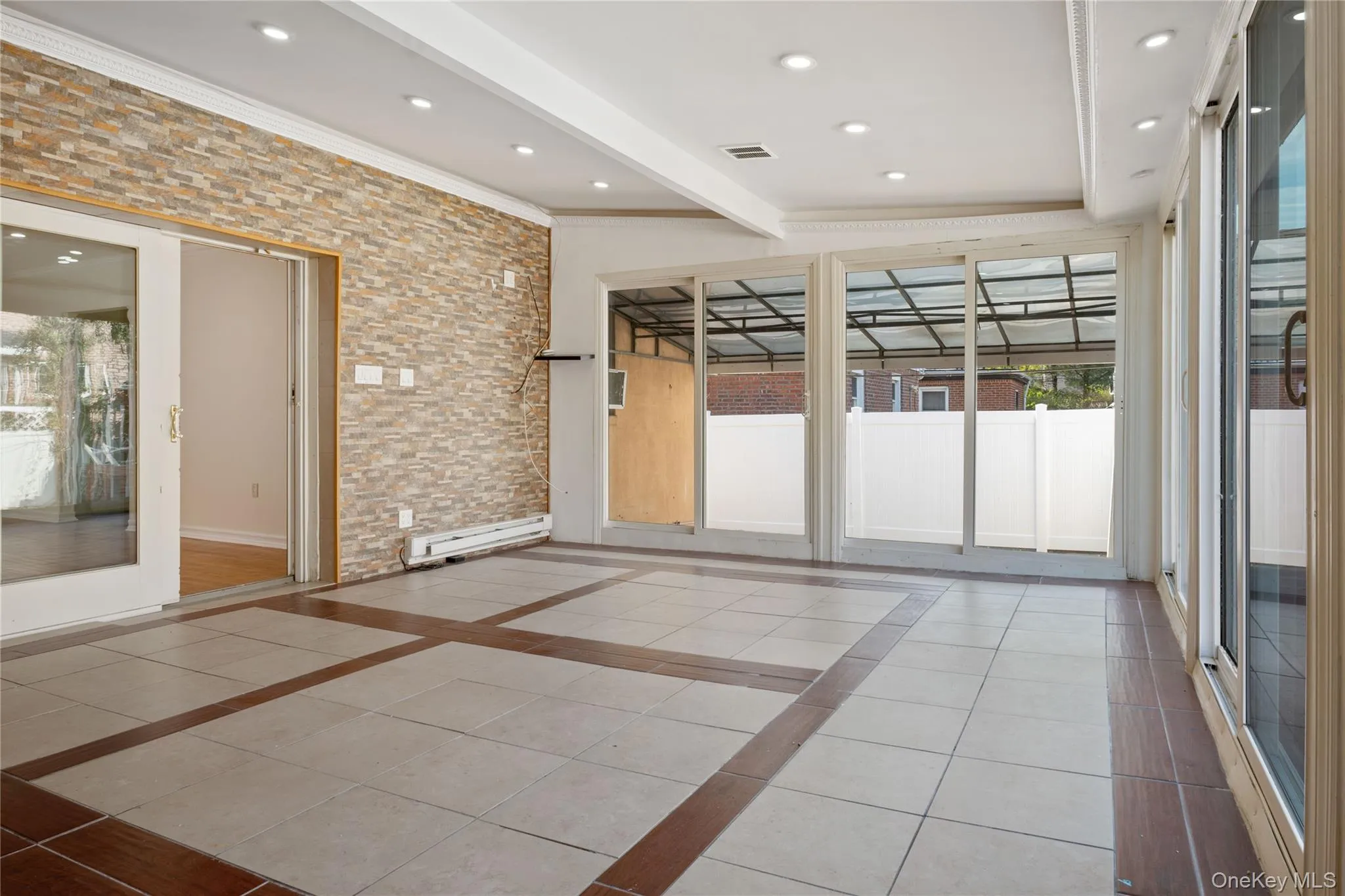 Spare room with crown molding, a baseboard heating unit, light tile patterned flooring, beamed ceiling, and visible vents Spare room with crown molding, a baseboard heating unit, light tile patterned flooring, beamed ceiling, and visible vents