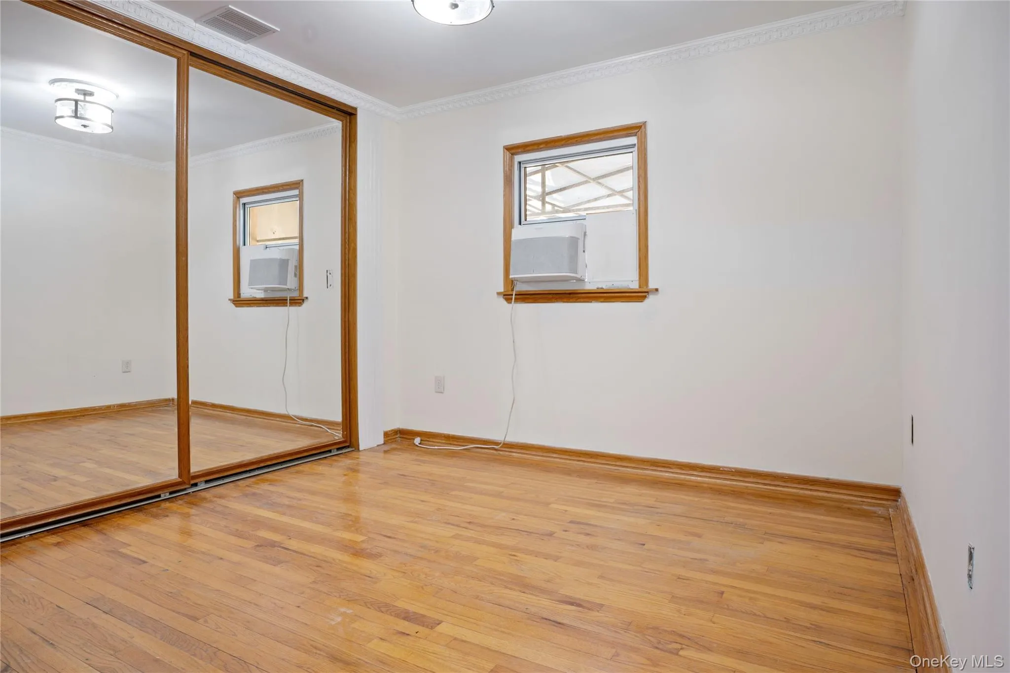 First Fl Unfurnished bedroom featuring visible vents, ornamental molding, a closet, baseboards, and hardwood / wood-style flooring First Fl Unfurnished bedroom featuring visible vents, ornamental molding, a closet, baseboards, and hardwood / wood-style flooring