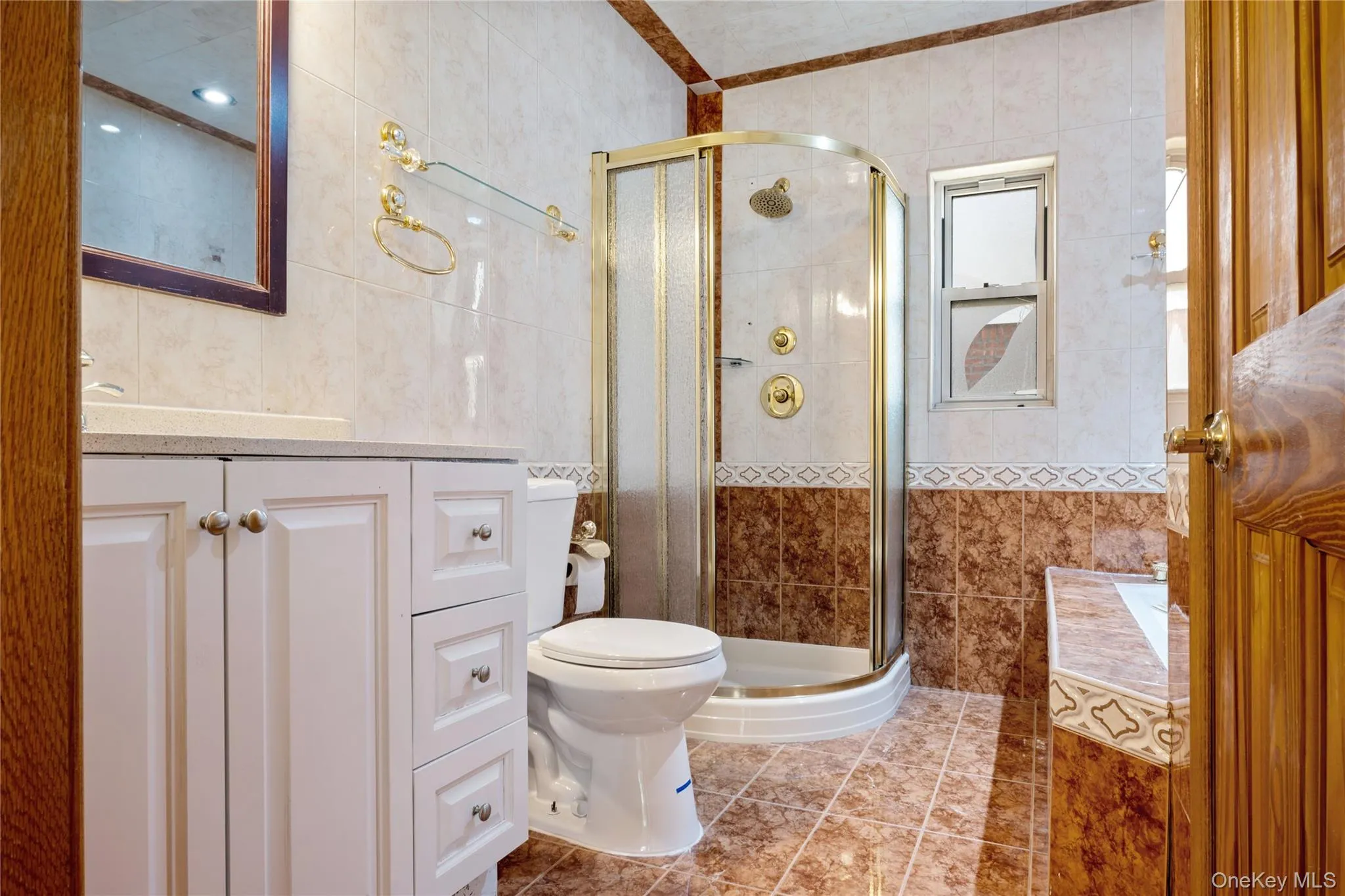 Bathroom with vanity, tile walls, tile patterned flooring, and a stall shower Bathroom with vanity, tile walls, tile patterned flooring, and a stall shower