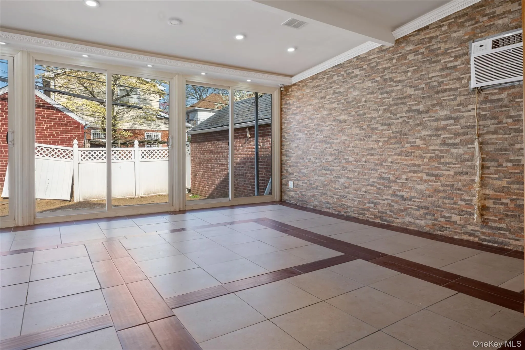 Unfurnished sunroom with visible vents, a wall mounted air conditioner, and beamed ceiling Unfurnished sunroom with visible vents, a wall mounted air conditioner, and beamed ceiling
